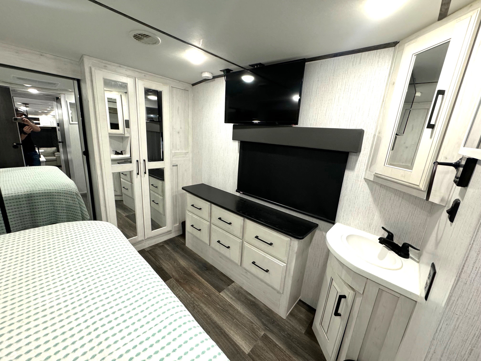 Spacious RV rental bedroom featuring a modern vanity, TV, and ample storage for comfortable travels.. Heartland Bighorn 2022