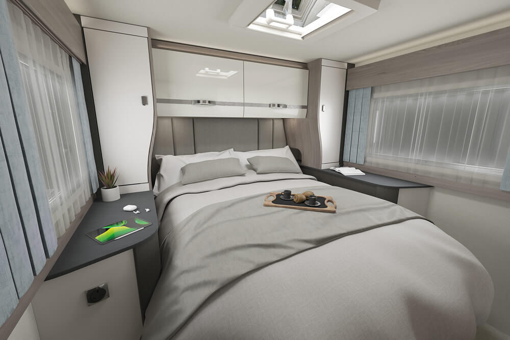 Experience comfort in this modern RV rental bedroom, featuring a cozy bed, ample storage, and natural light.. Swift Voyager 494 (NO PETS) 2025