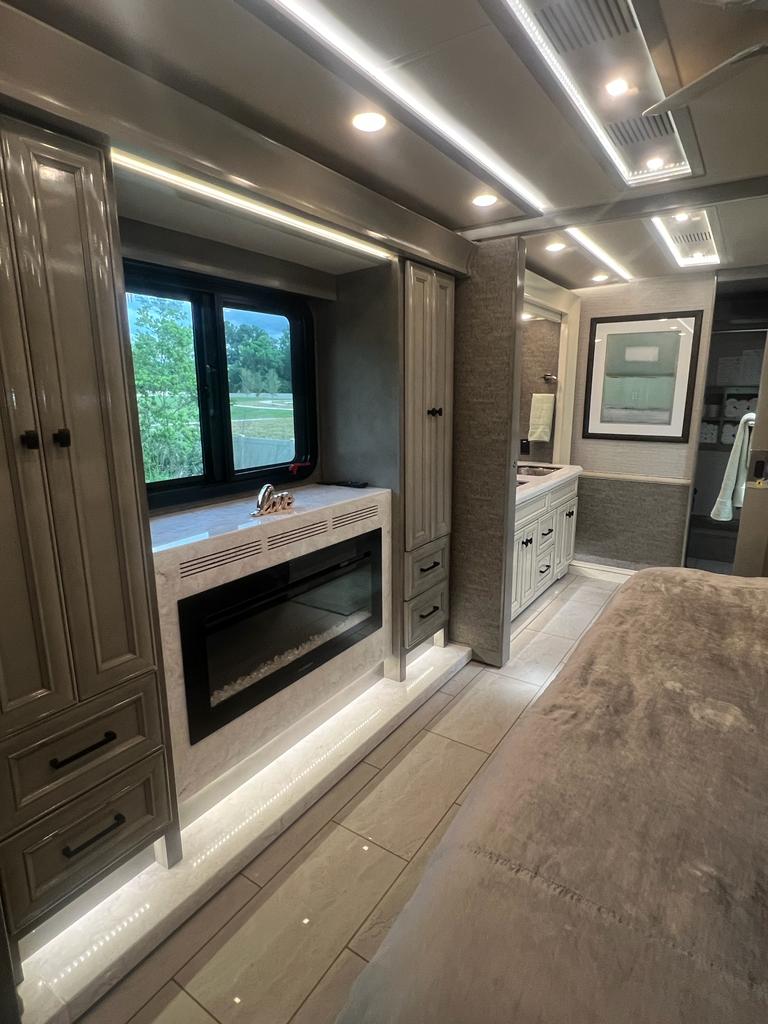 Luxury RV rental interior features a spacious bedroom with fireplace, tiled floors, and a modern bathroom, perfect for travel comfort.. Allegro Allegro Bus 2020