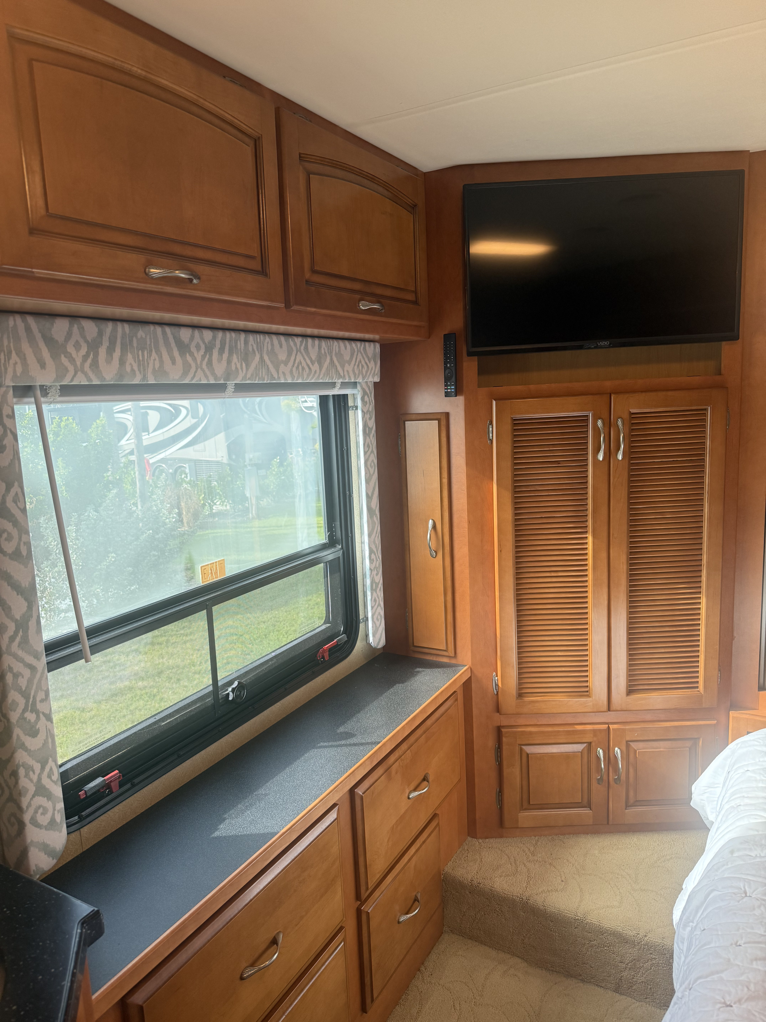 Inside this RV rental: wood cabinets, window views, TV, and plush carpeted bedroom space.. Kountry Star Kountry Star Motorhome 2008