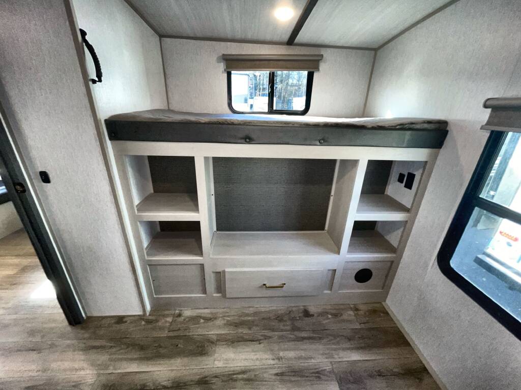 RV rental: Interior view of a bunk bed with built-in shelves and storage drawer, complete with a window and wood-look floor.. Forest River Salem Hemisphere 2023