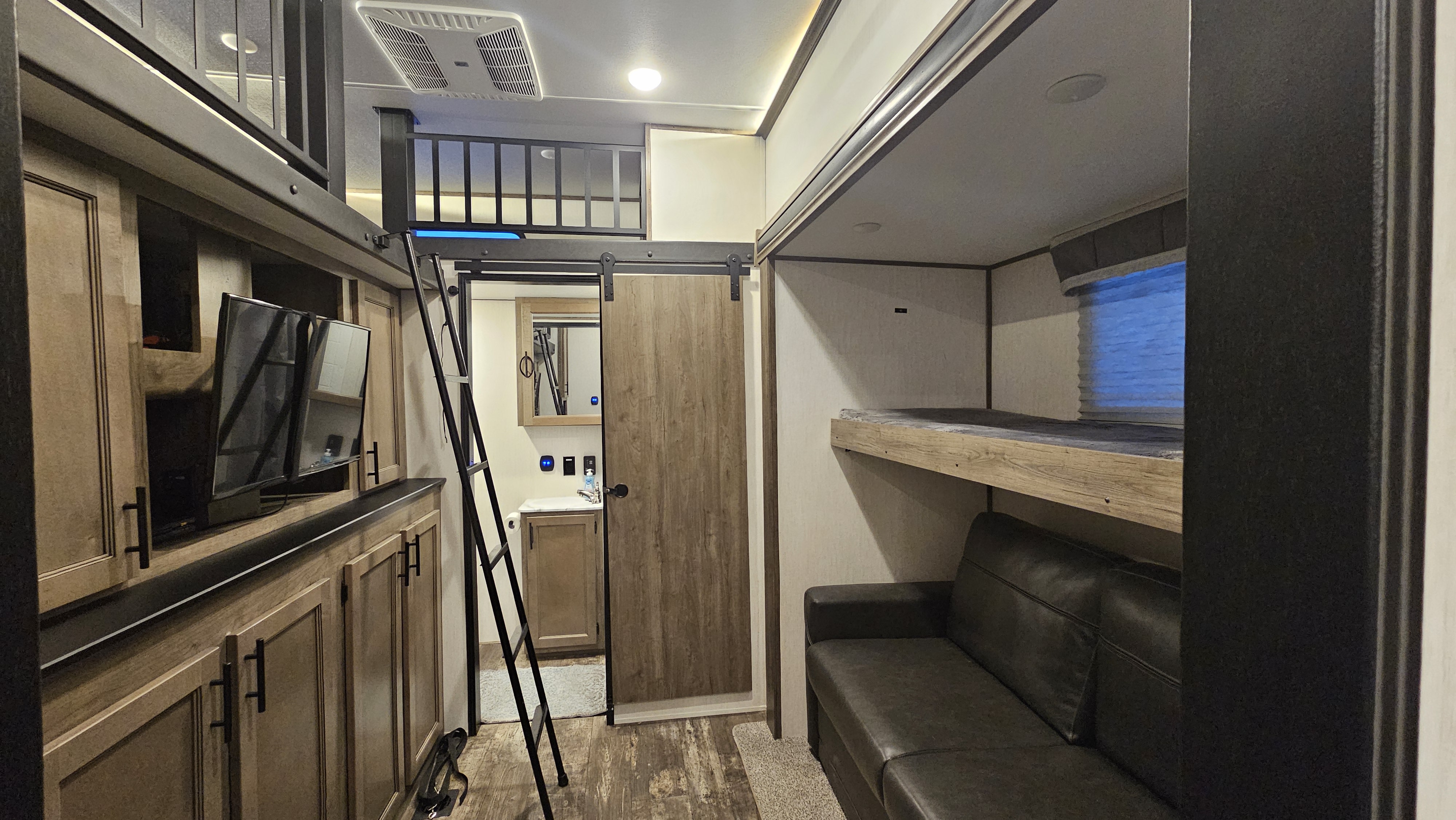 Modern RV rental interior: bunk beds, loft, and entertainment center offer comfort for your journey.. Forest River Sabre 2022