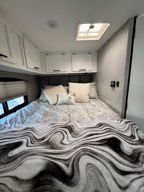 This RV rental offers a comfortable bedroom with a large bed, overhead storage, and a skylight for natural light.. 1FDWE3FN5NDC05003 Coachman Crosstrail XL 23XG 2022