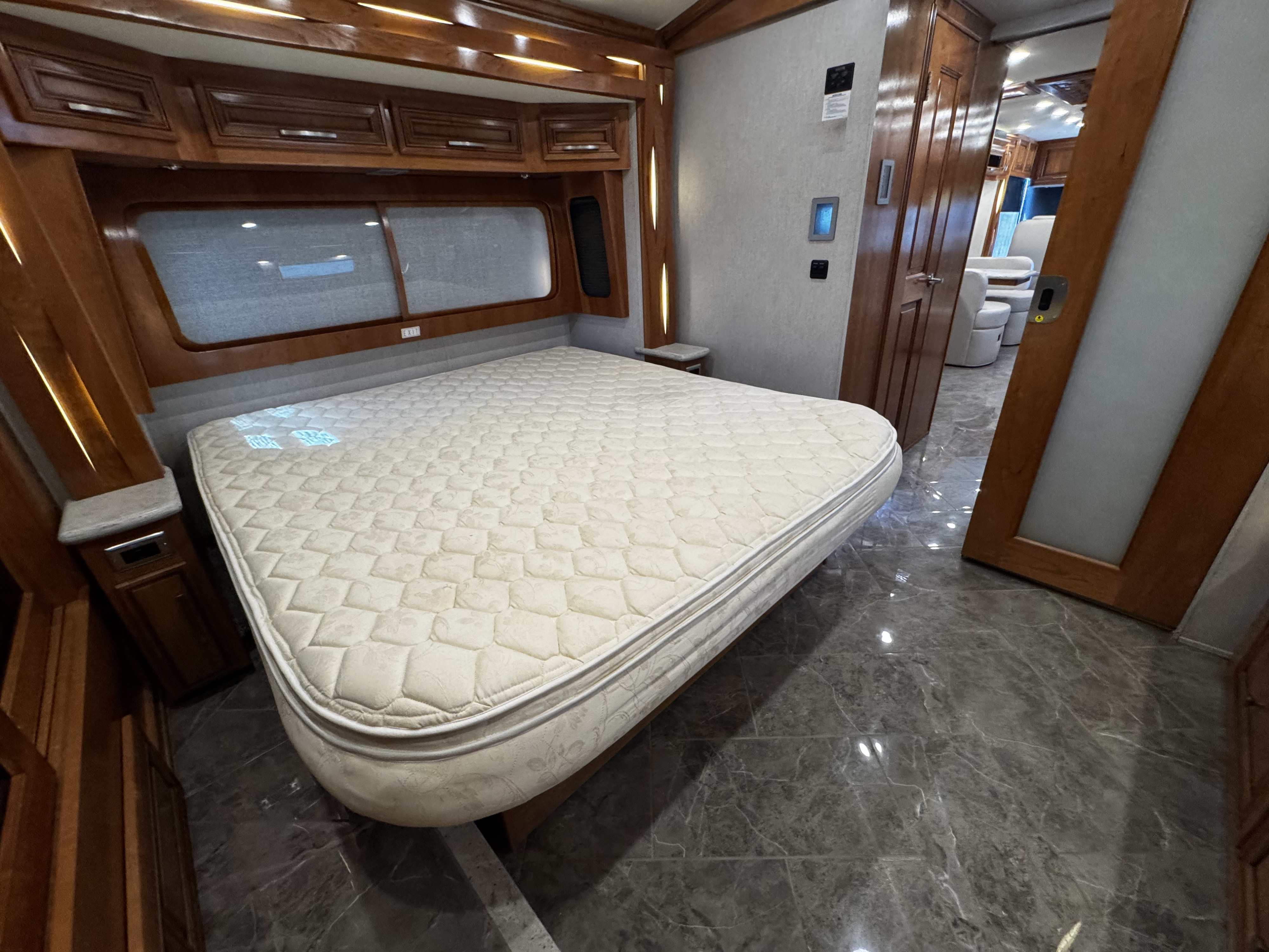 Comfortable RV rental bedroom with a large mattress, ample wood cabinetry, and polished tile floors. Ready for your journey.. New Aire New Aire Motorhome 2020