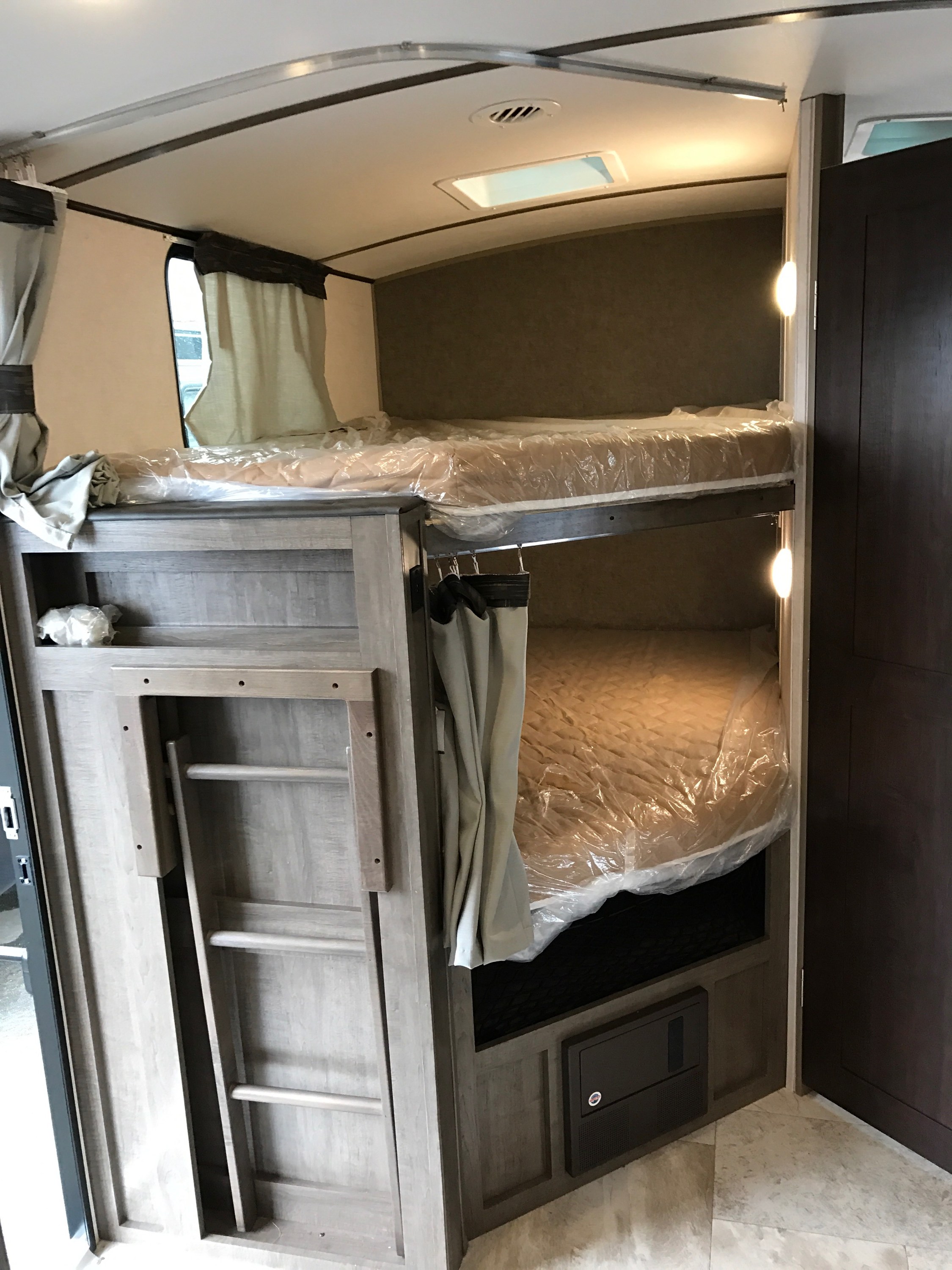 RV rental: Compact interior showing bunk beds, a stowed ladder, and an electrical panel for a family-friendly space.. Forest River Surveyor 2018