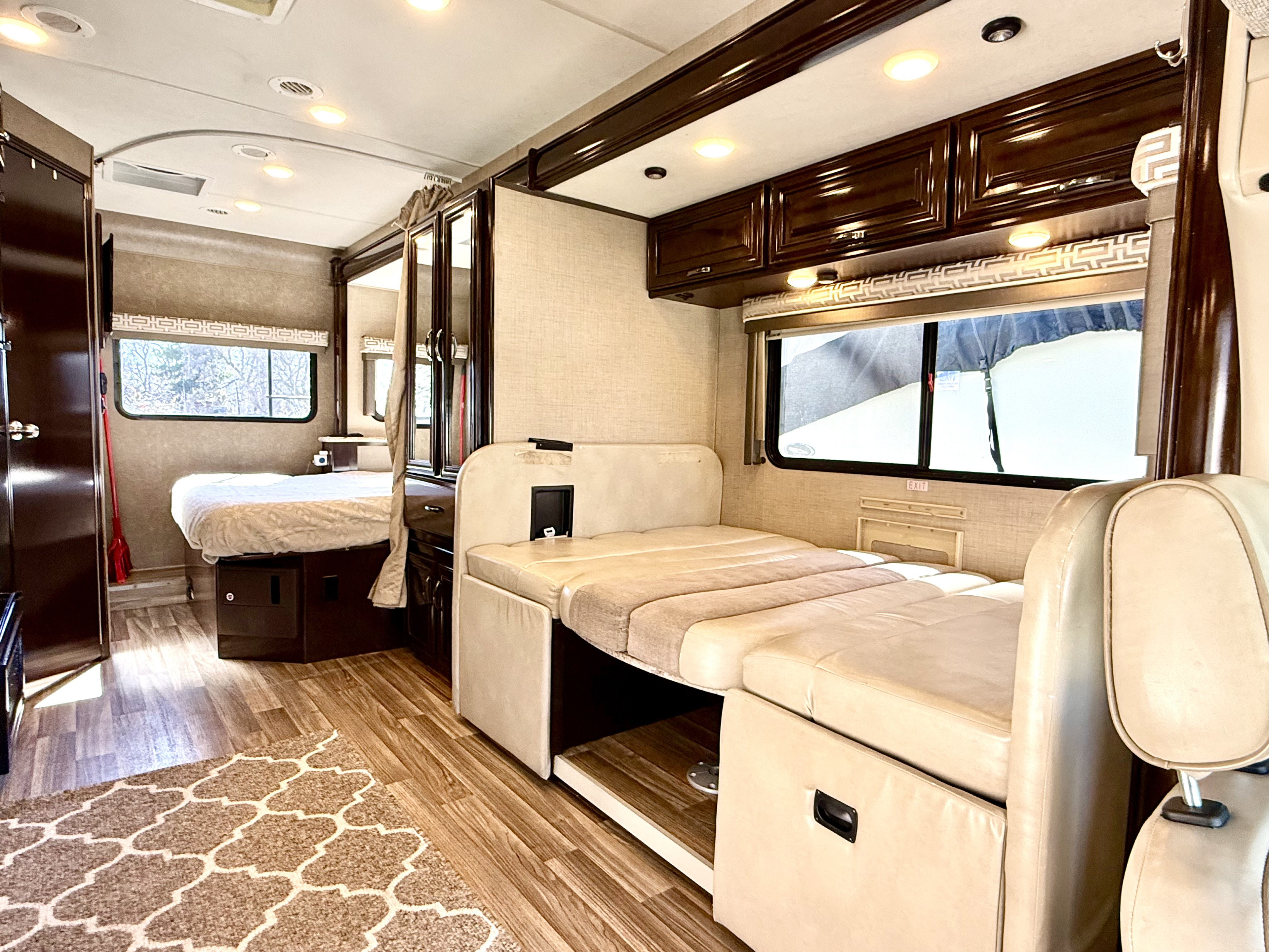 Interior of an RV rental: comfortable bedroom, convertible dinette, and cozy living area, ideal for travel.. Thor Quantum 2017