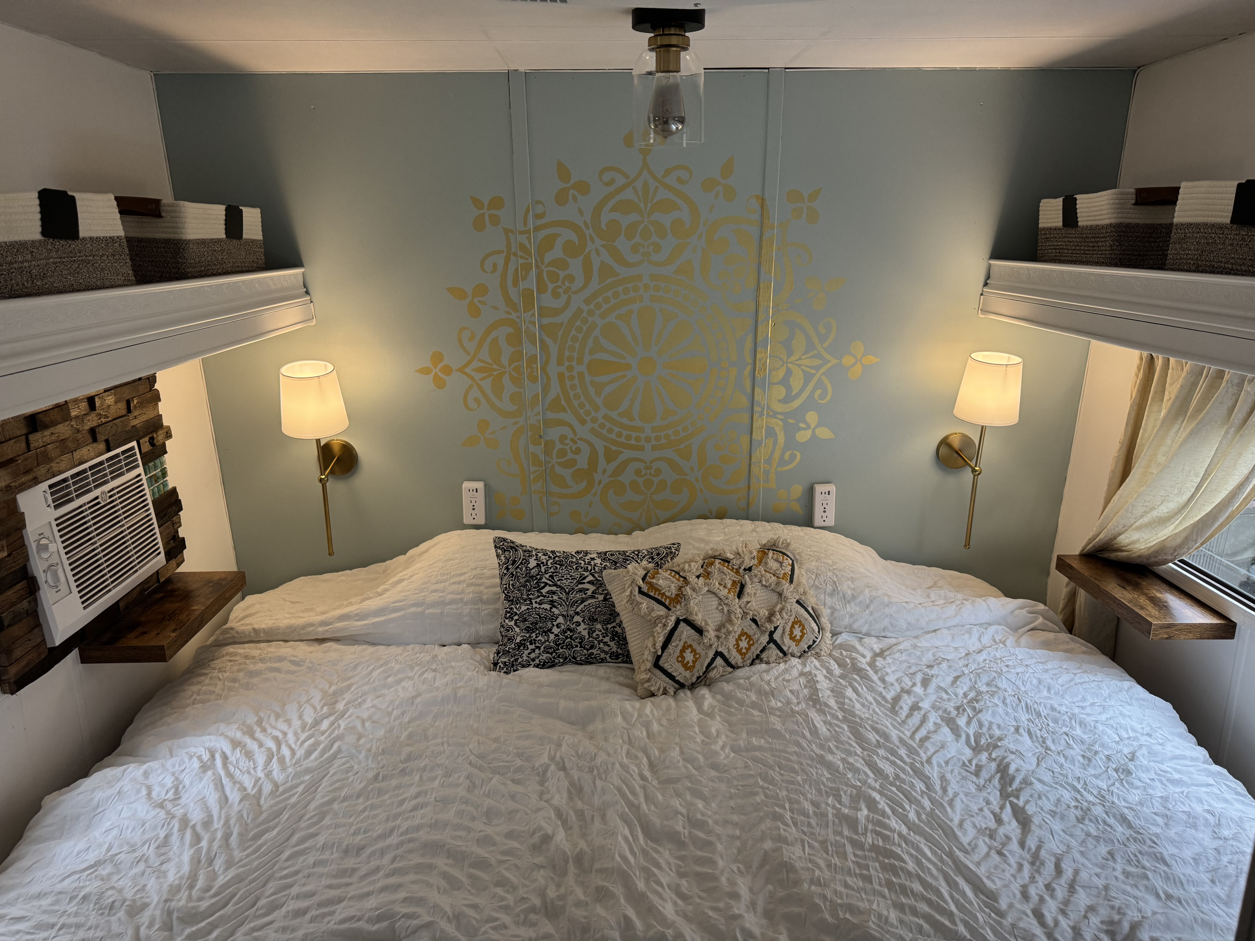 Cozy RV rental bedroom with blue walls, gold stencil, and large bed, perfect for a relaxing getaway.. Fleetwood Wilderness Yukon 1987