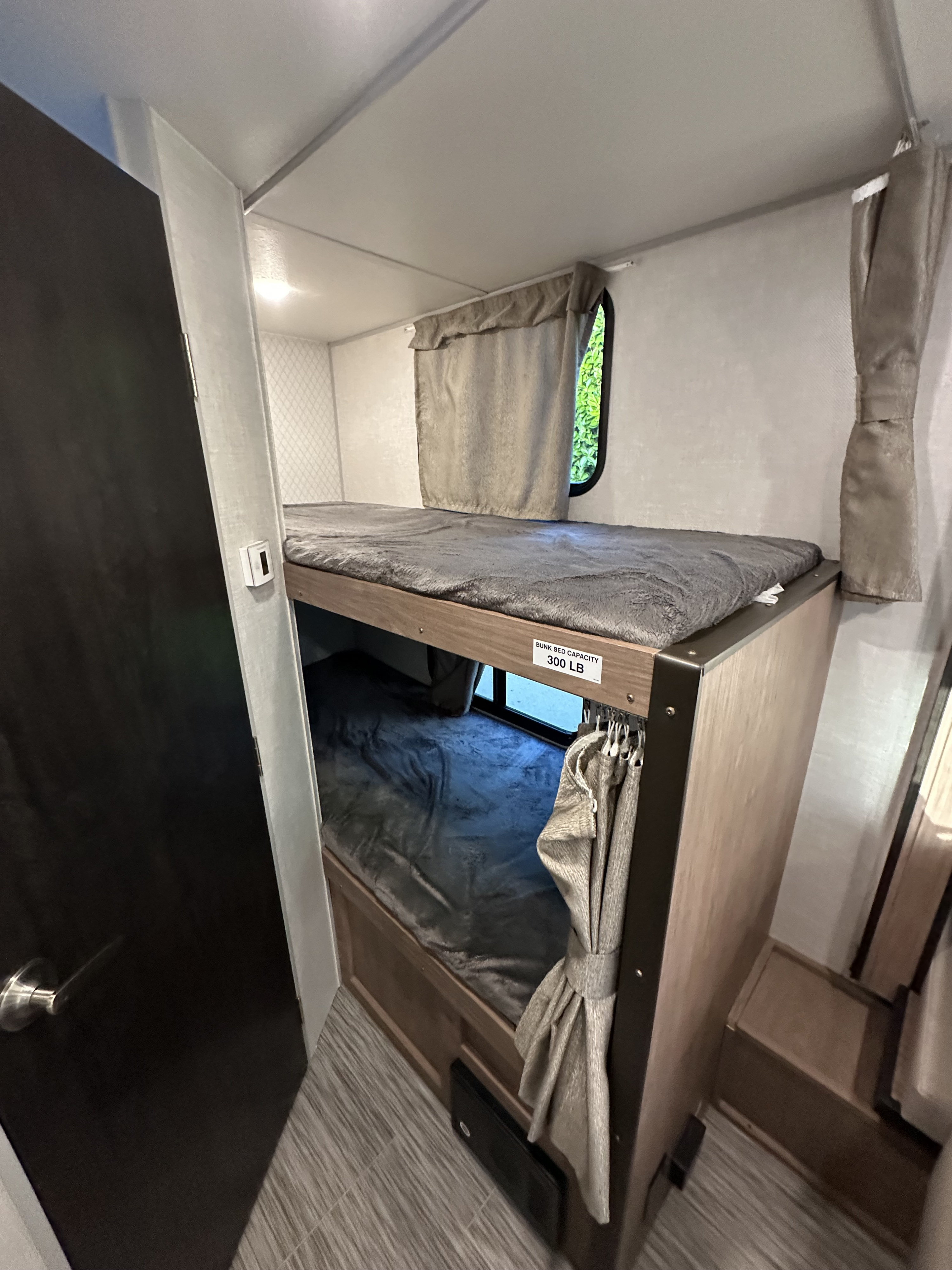 RV rental interior: stacked bunk beds with privacy curtains and a 300 lb weight limit, providing cozy sleeping.. No Boundaries 19 2021