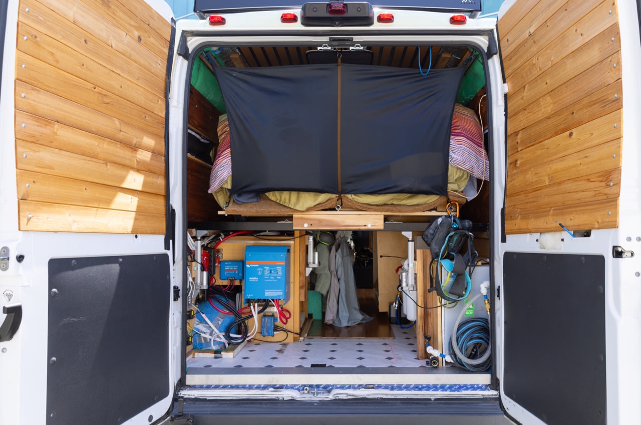 Explore a comfortable RV rental campervan conversion from the rear, revealing its cozy bed, electricals, and water system.. Dodge Ram Promaster Cargo Van 2500 159" WB 2018