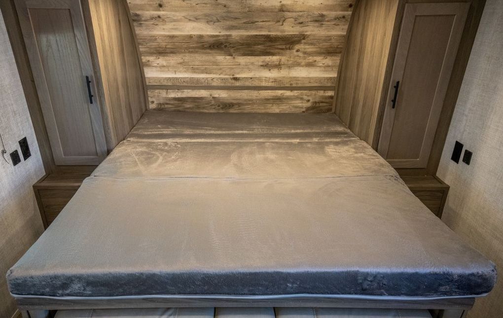 Cozy RV rental bedroom with plush grey mattress, wooden headboard, and storage cabinets for comfortable travel.. Gulf Stream 248BH 2022