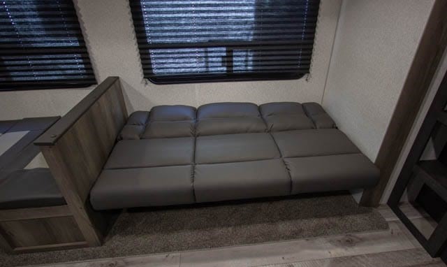This RV rental features a versatile sofa that converts into a bed, offering comfortable sleeping and seating in a compact living space.. K-Z Manufacturing Sportsmen 261BHKSE 2022