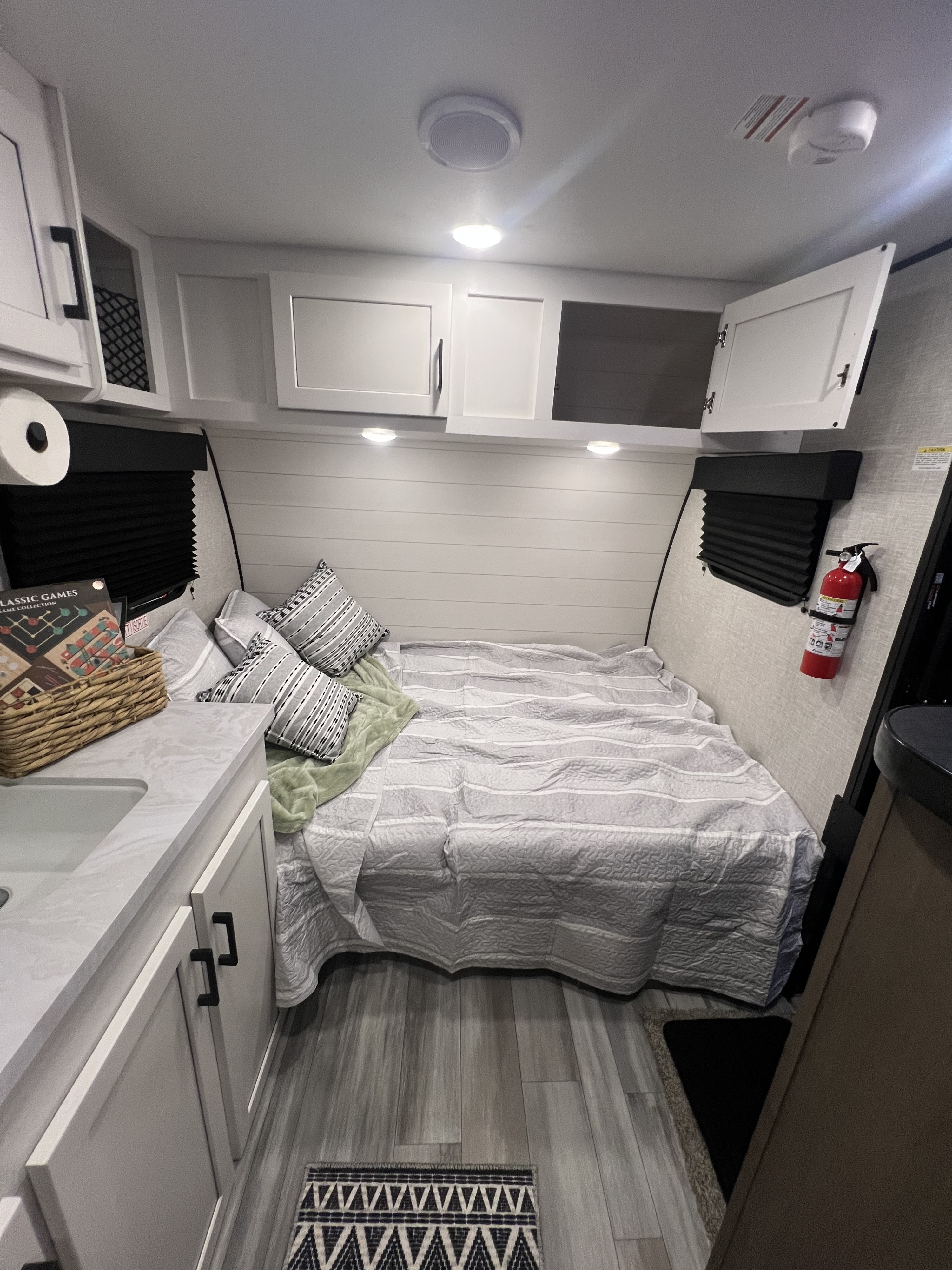 Cozy rv rental bedroom interior featuring a comfortable bed, modern white cabinets, and a compact sink area.. Jayco Jay Flight SLX Baja Edition 2024