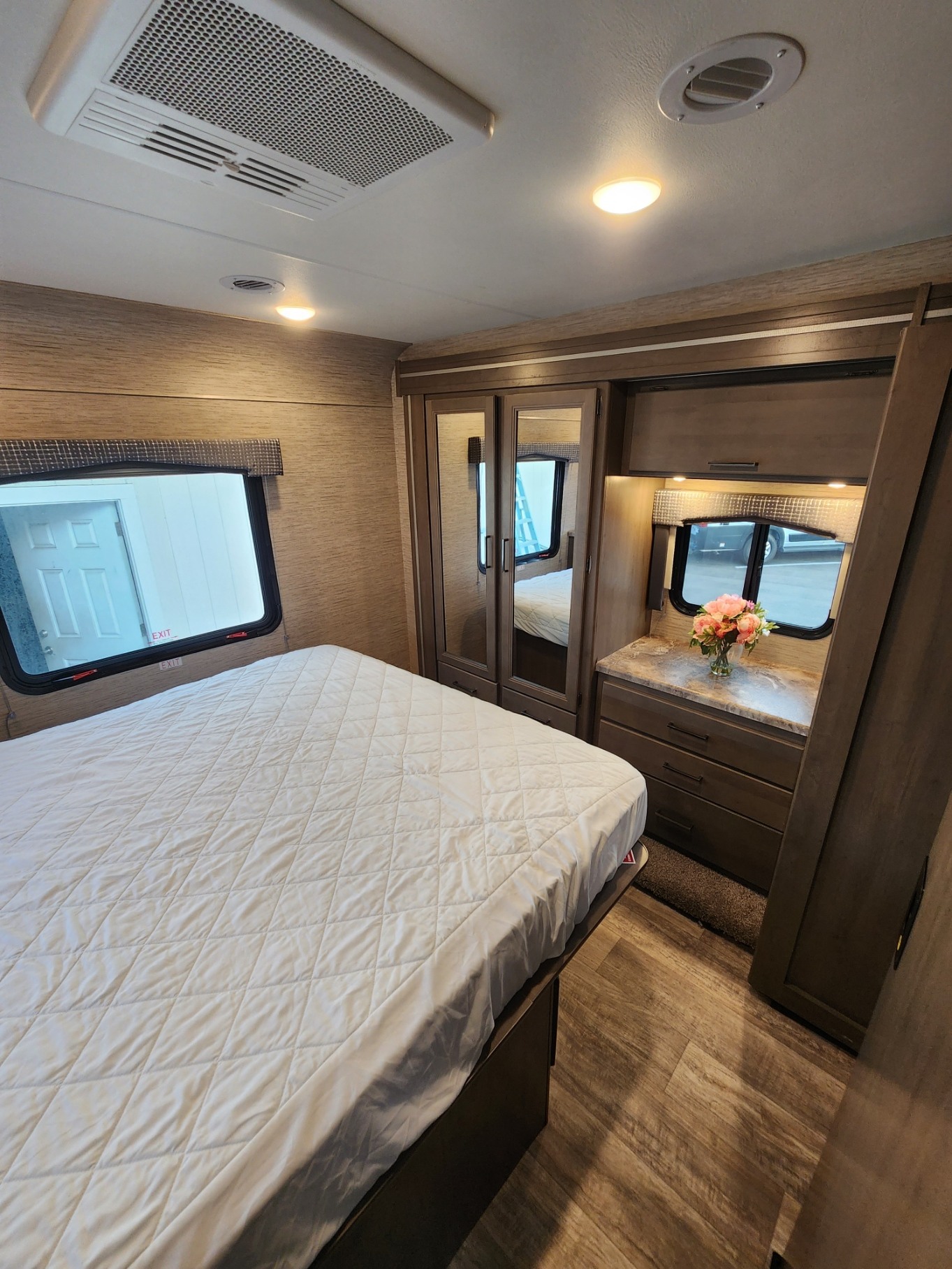 Spacious RV rental bedroom with queen bed, ample storage, and two large windows for a comfortable stay.. Thor Motor Coach Chateau 2023