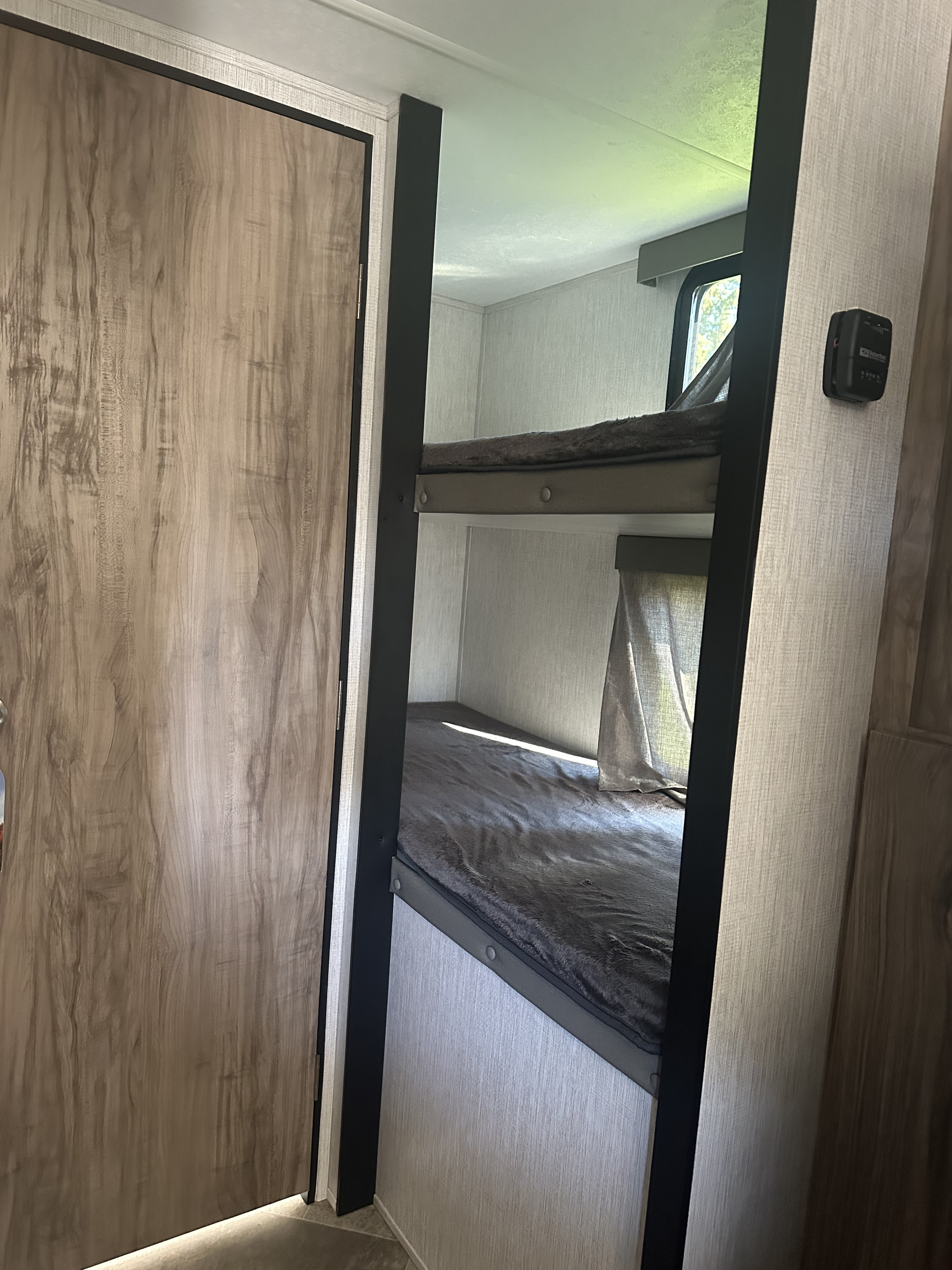 RV rental: Interior with wood-look door and bunk beds with grey bedding, ideal for family travel.. Palomino Real Lite Mini 2022