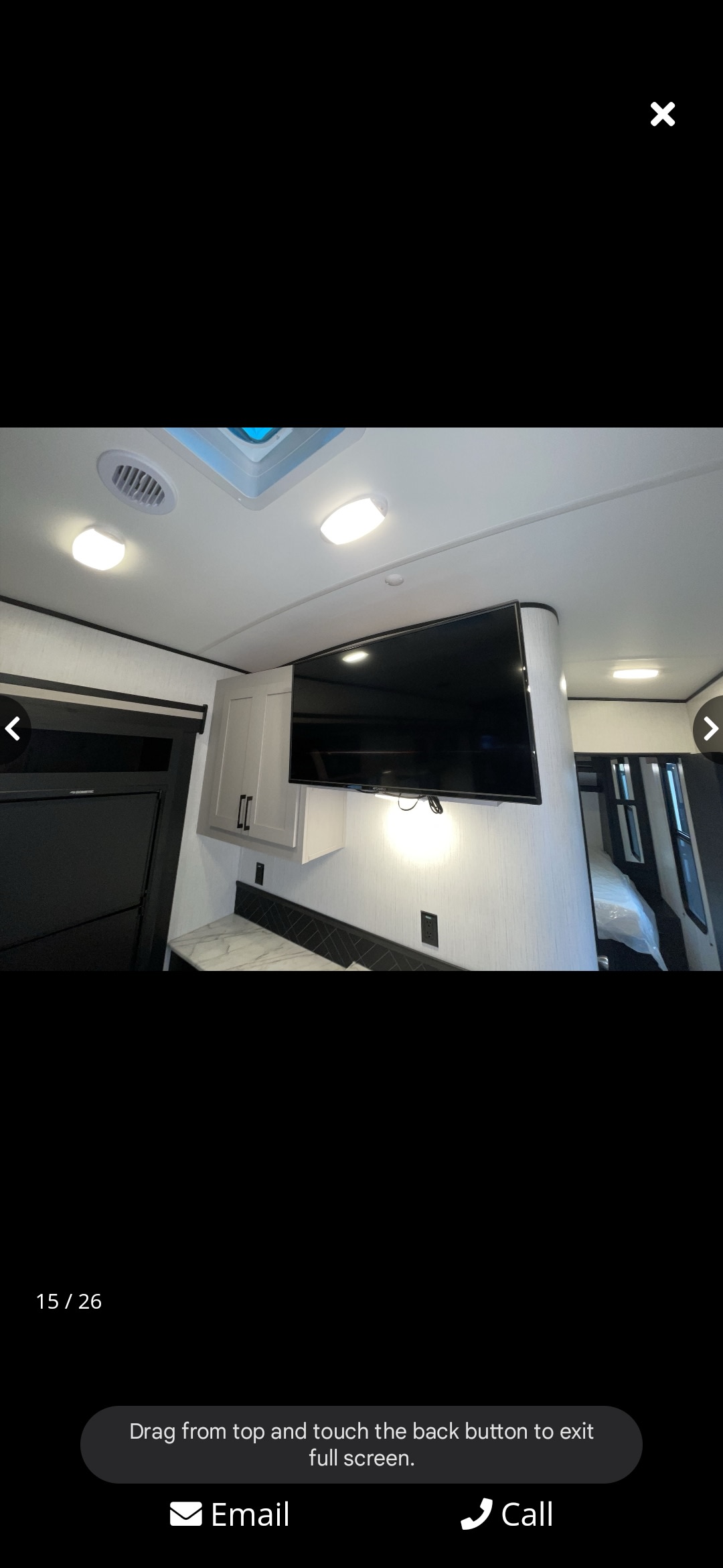 Modern RV rental interior with a wall-mounted TV, stylish cabinetry, and view of a cozy sleeping area.. Heartland RVs Fuel Toy Hauler 2022