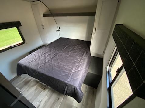 Spacious RV rental bedroom with a comfortable bed, large windows, and built-in storage. Ideal for travel adventures.. KZ 332BHKSE 2022