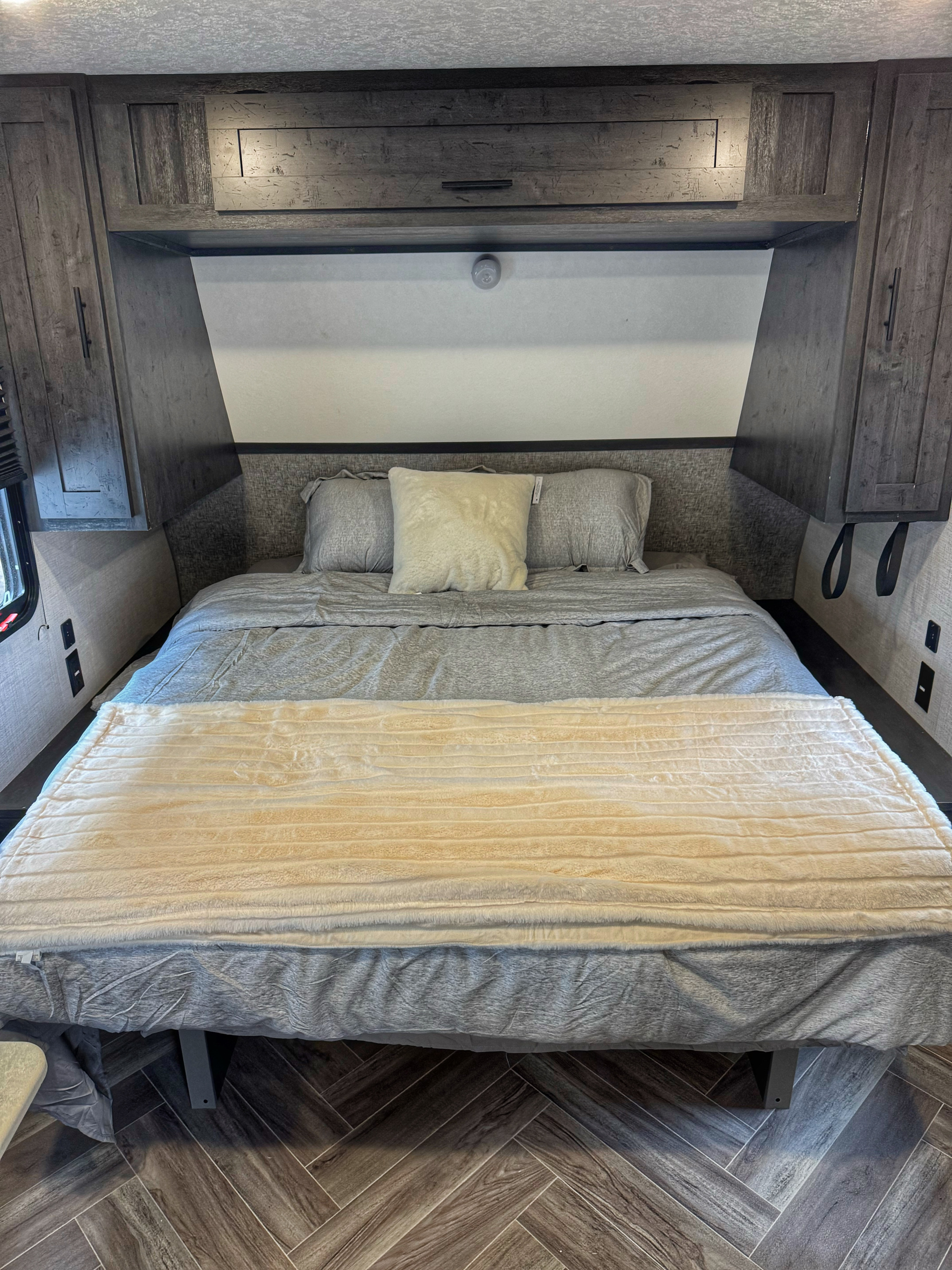 Well-appointed RV rental bedroom with a comfy bed, grey linens, and integrated storage cabinets. Perfect for your travels.. Ozark Ascent 2020