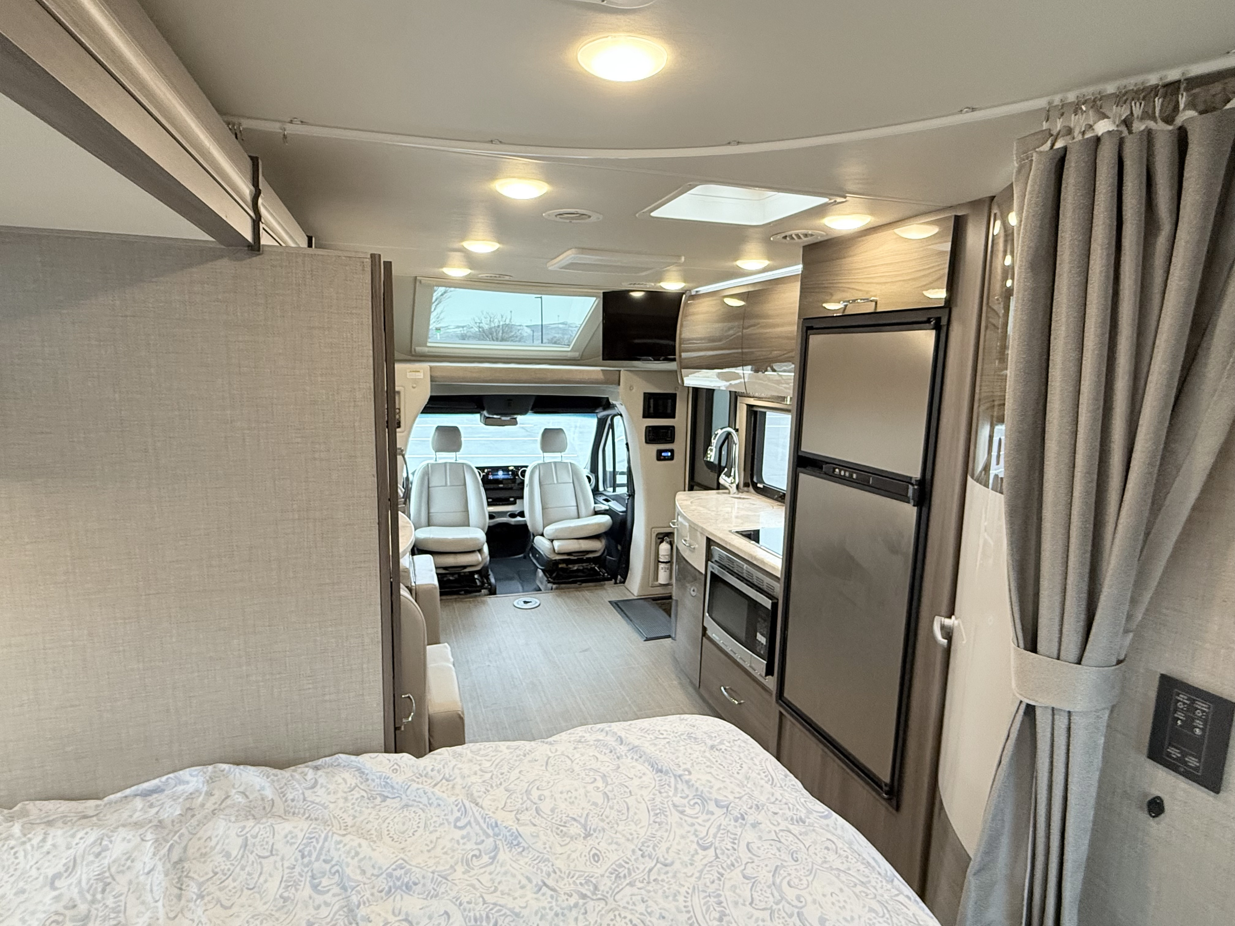 Spacious RV rental interior featuring a full kitchen, bedroom, and driver's cab. Perfect for your next road trip adventure.. Thor Tiburon 2022