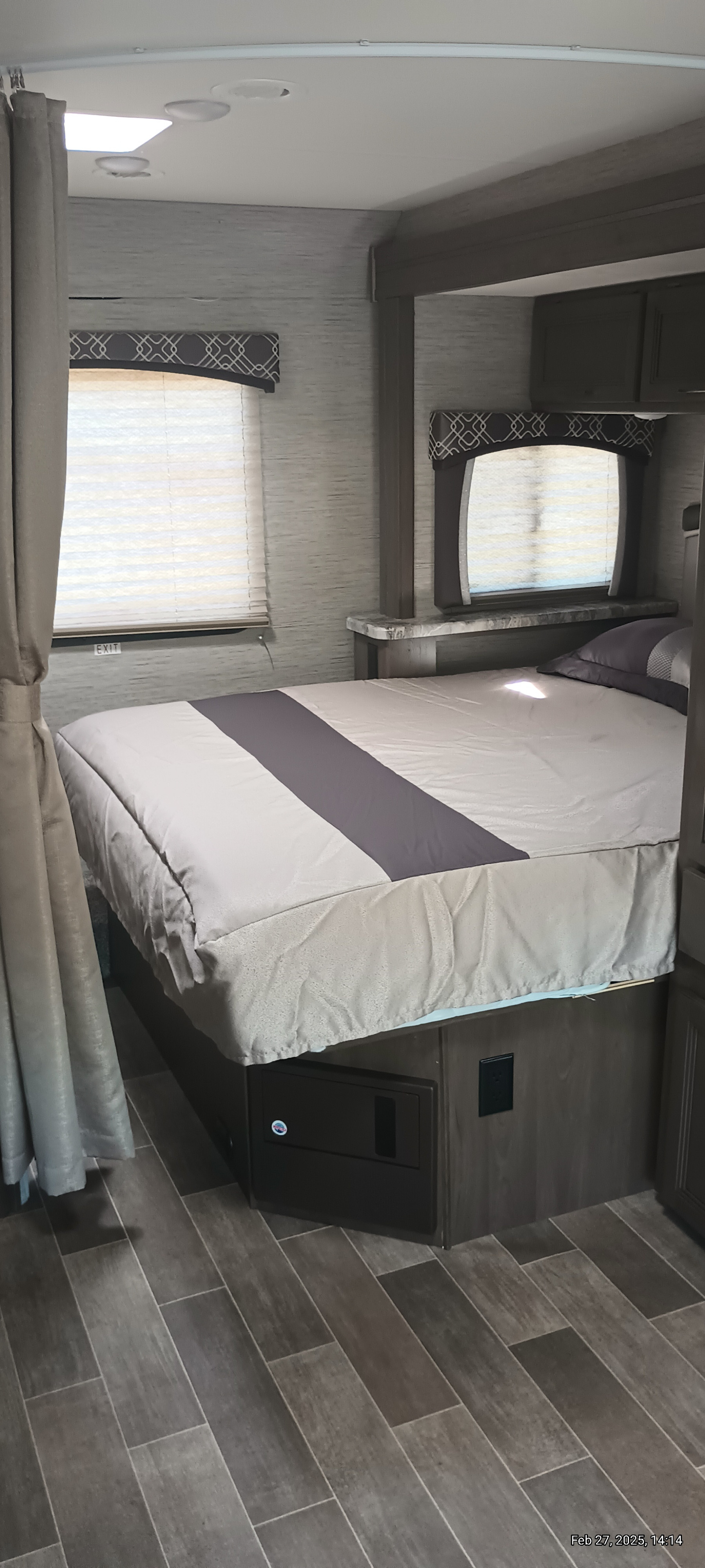 Explore a spacious RV rental bedroom featuring a comfy bed, window blinds, and practical under-bed storage.. Thor Motor Coach Chateau 2021