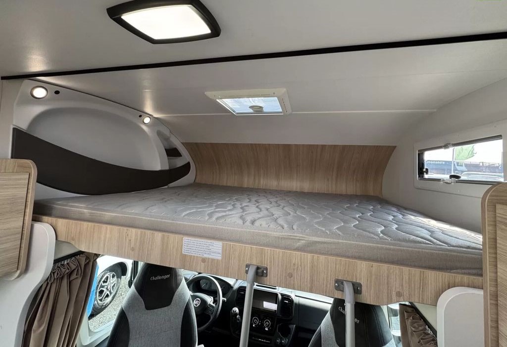 RV rental: Bright view of a comfortable over-cab bed in a modern motorhome interior with a skylight.. Challenger C194 START EDITION 2025