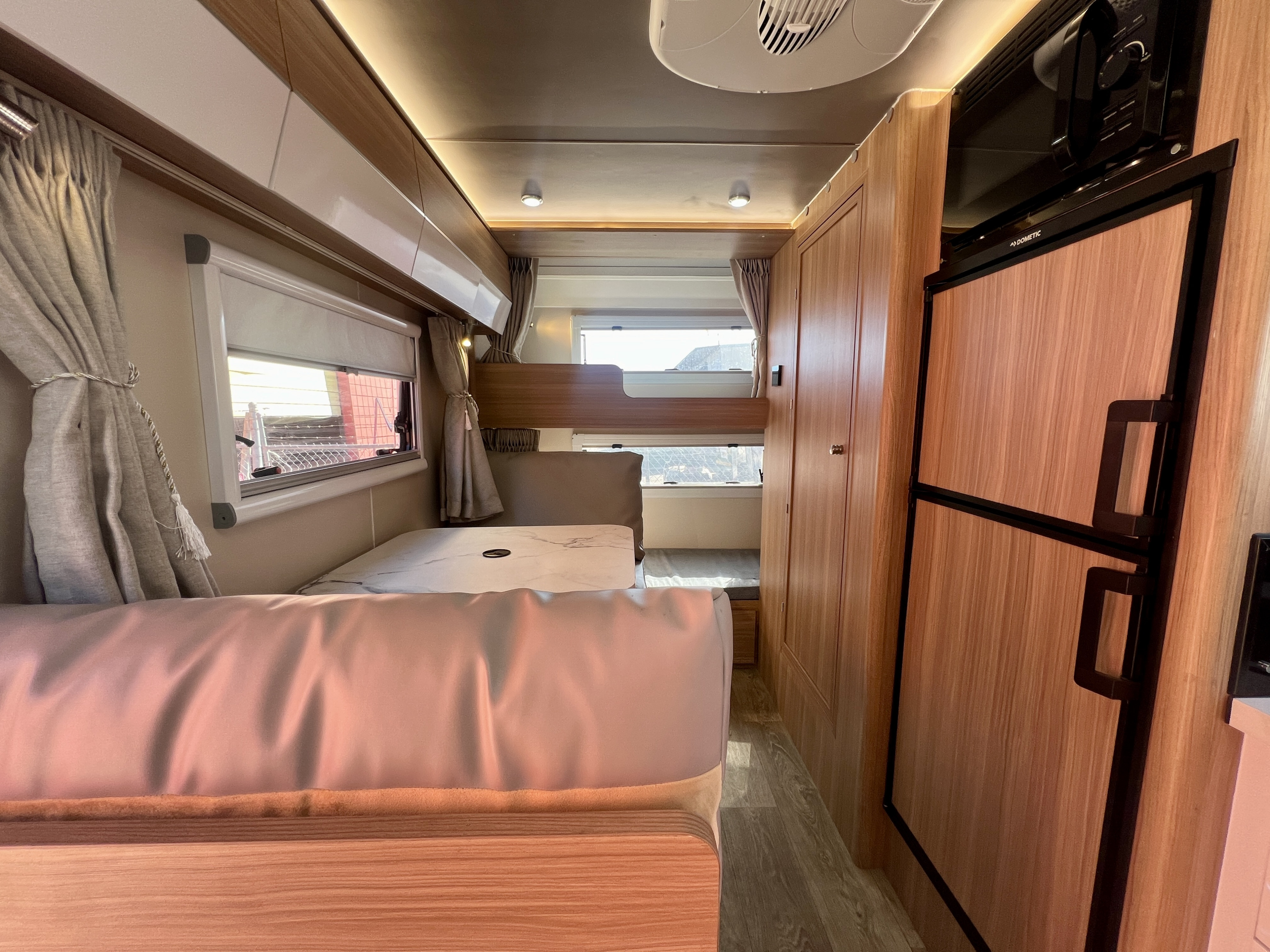 RV rental interior showcasing smart design with comfortable bunk beds, integrated refrigerator, and storage cabinets for travel adventures.. Black Series HQ17 2025