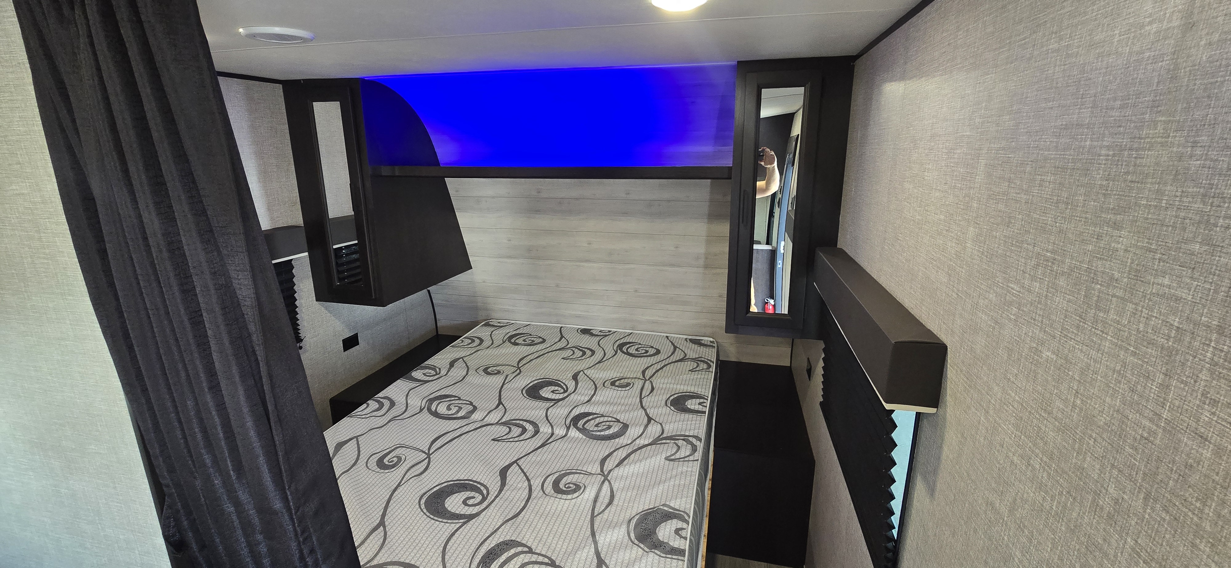 RV rental bedroom: a cozy space with a patterned mattress, overhead storage, and vibrant blue accent lighting.. Jayco Jay Flight SLX 2022