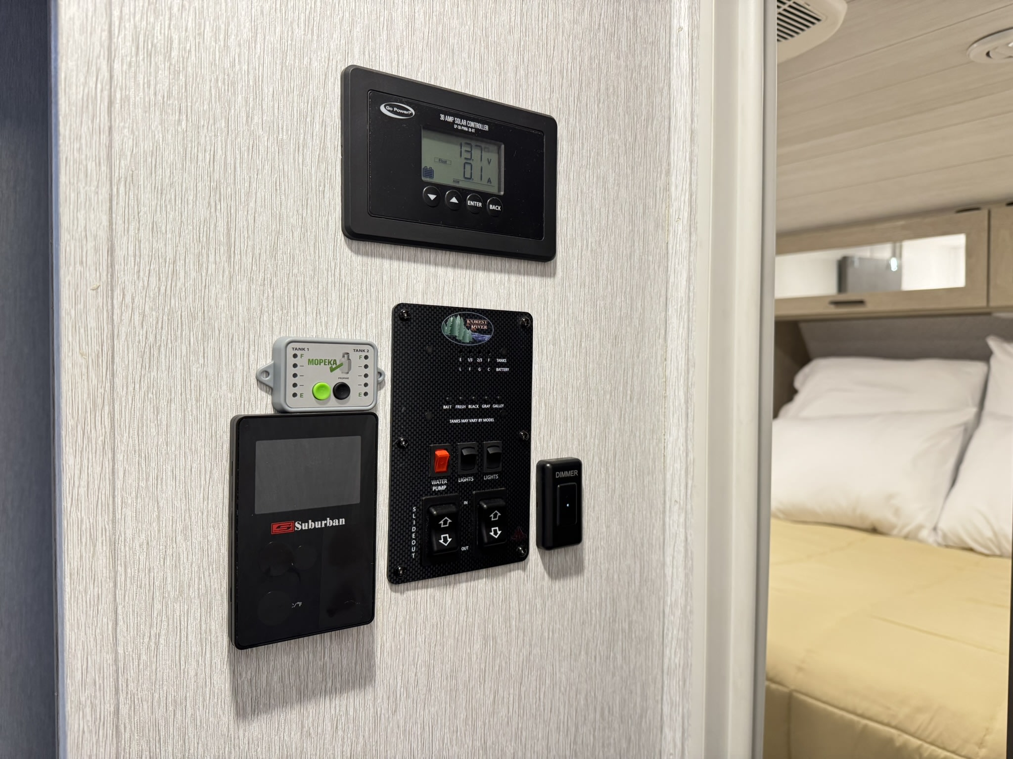 RV rental control panel featuring solar, water tank, climate, and lighting controls, vital for comfortable travel.. Forest River Wildwood Platinum 2024