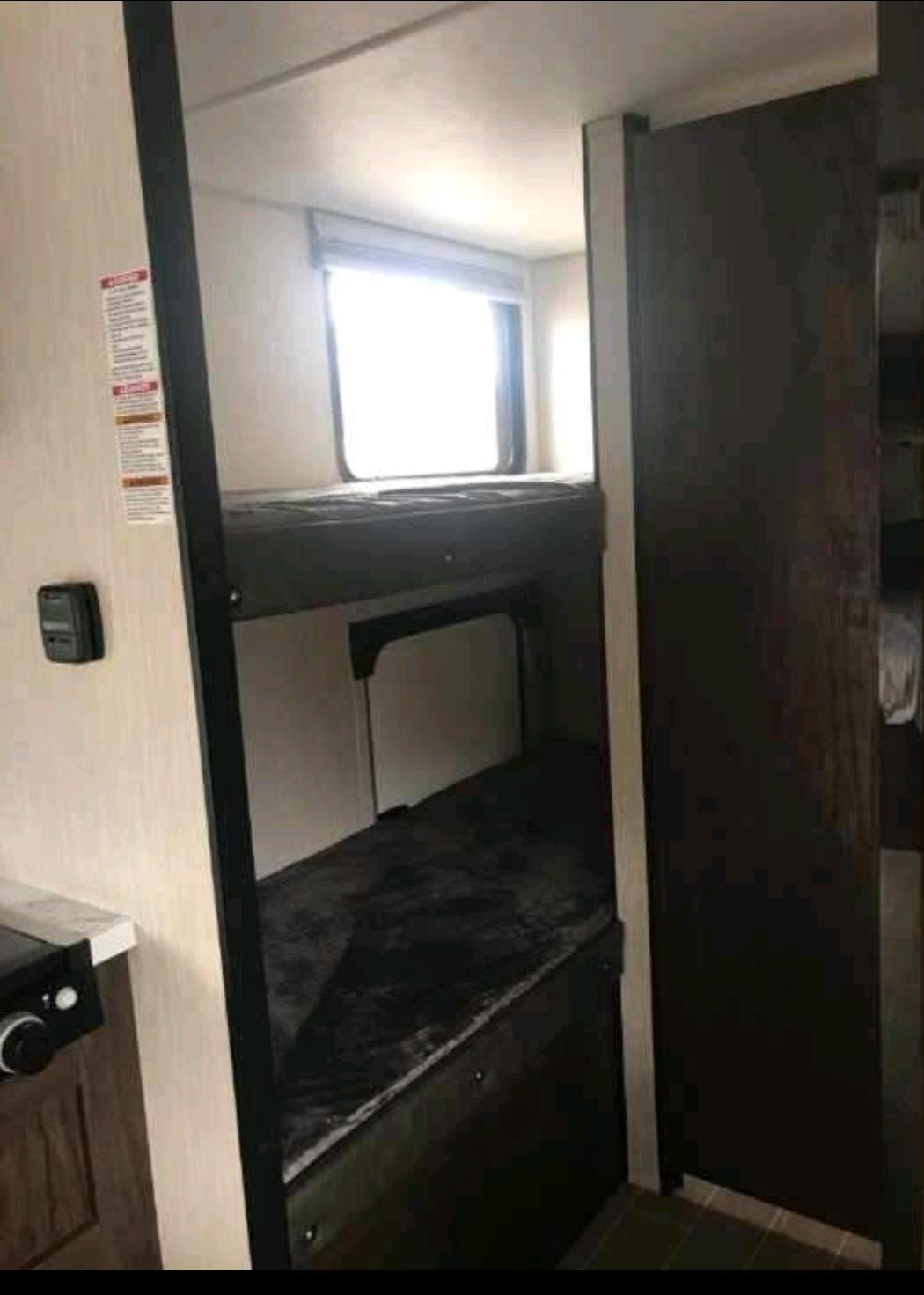 RV rental interior: cozy bunk beds and window create a comfortable sleeping area for your next adventure.. Forest River Cherokee Wolf Pup 2020