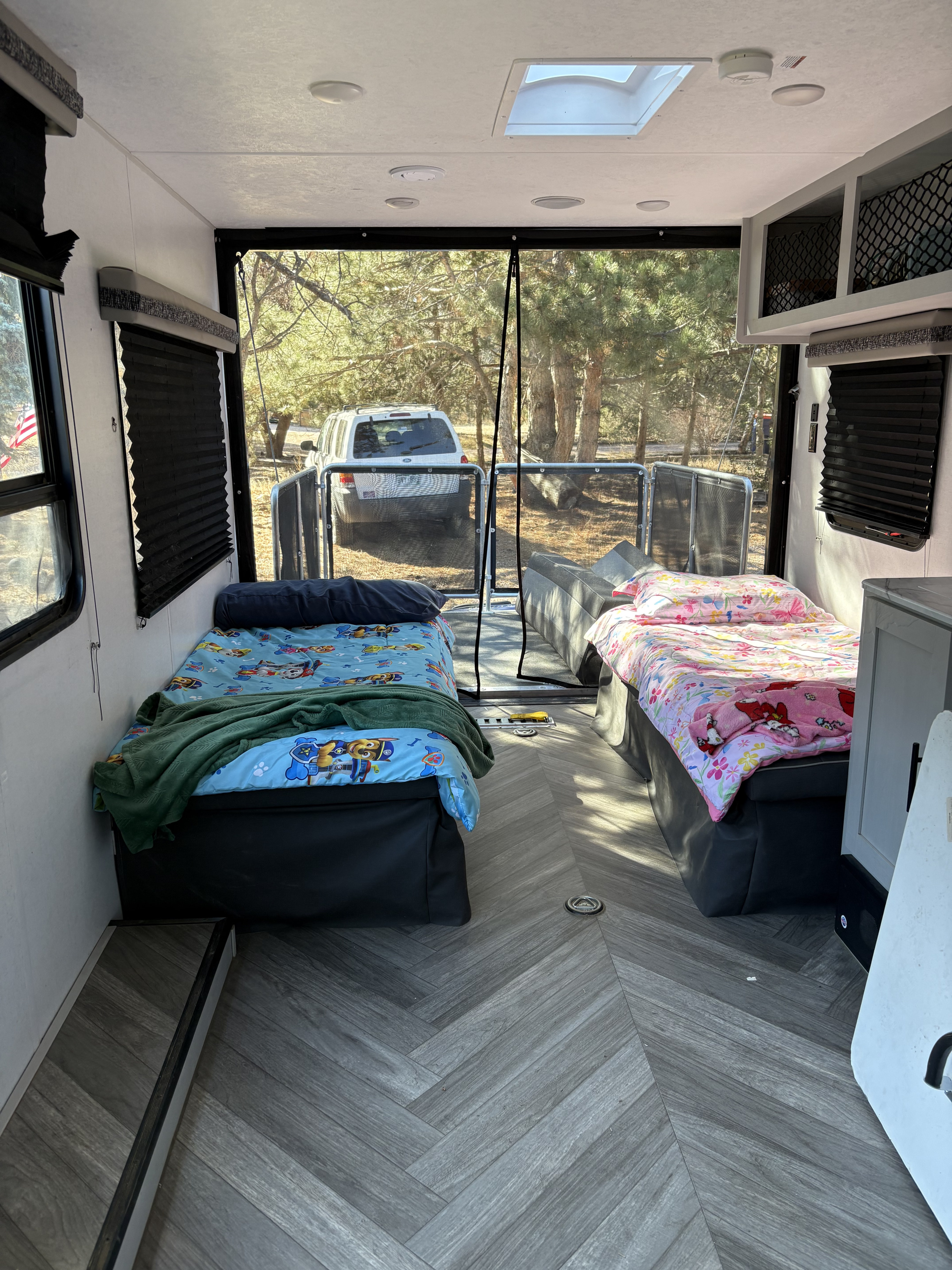 Cozy RV rental toy hauler interior with two beds & outdoor views for family adventures.. Forest River Fxs Wildwood 2021