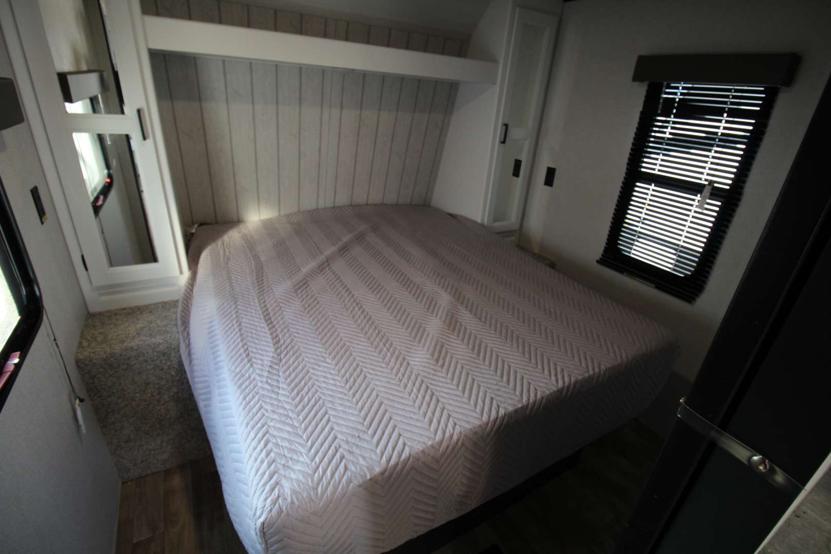 RV rental bedroom: bright interior with a comfortable bed, windows, and built-in storage.. Keystone Hideout 2022