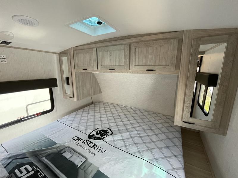 RV rental travel trailer bedroom with patterned bed, light wood cabinets, and window. Ready for your adventure.. Cruiser Rv Corp Shadow Cruiser 2022
