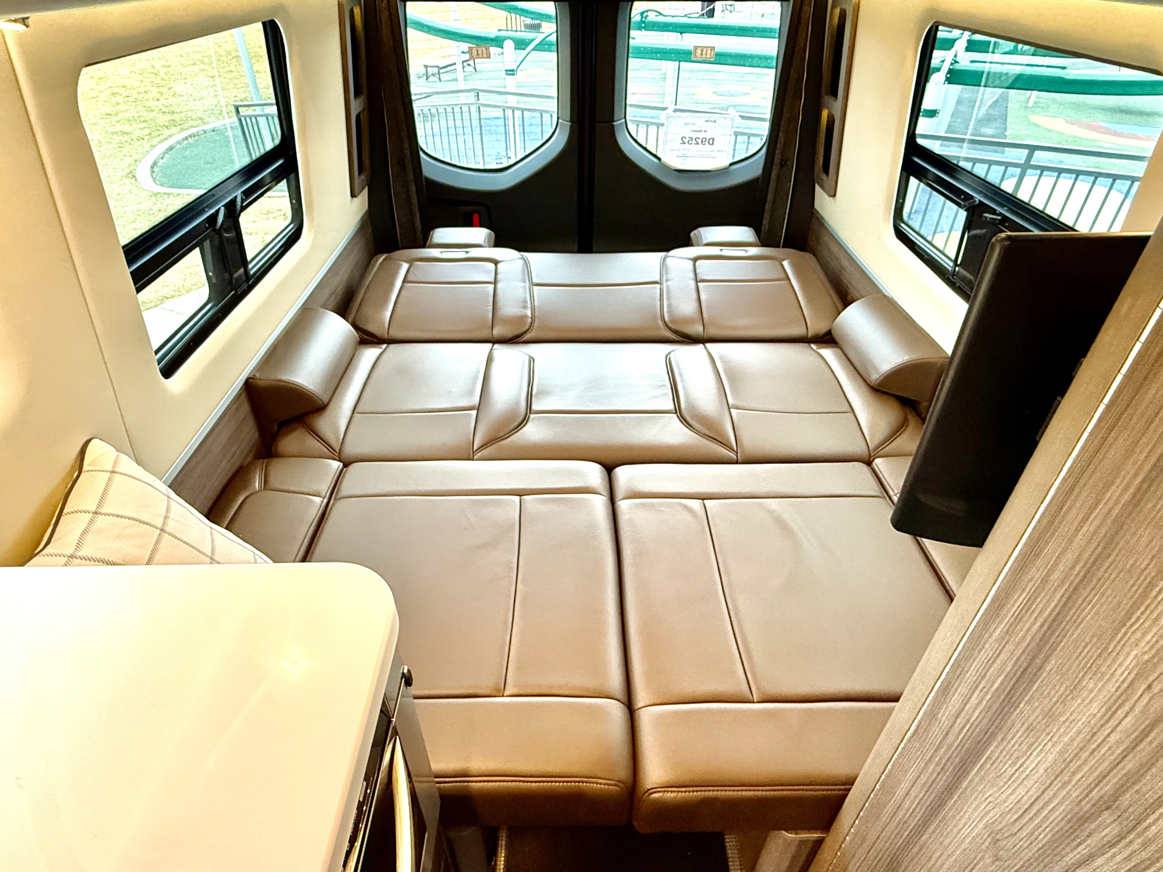 Spacious RV rental interior with comfortable tan leather seating that converts to a bed. Perfect for your next road trip.. Airstream Interstate 2021