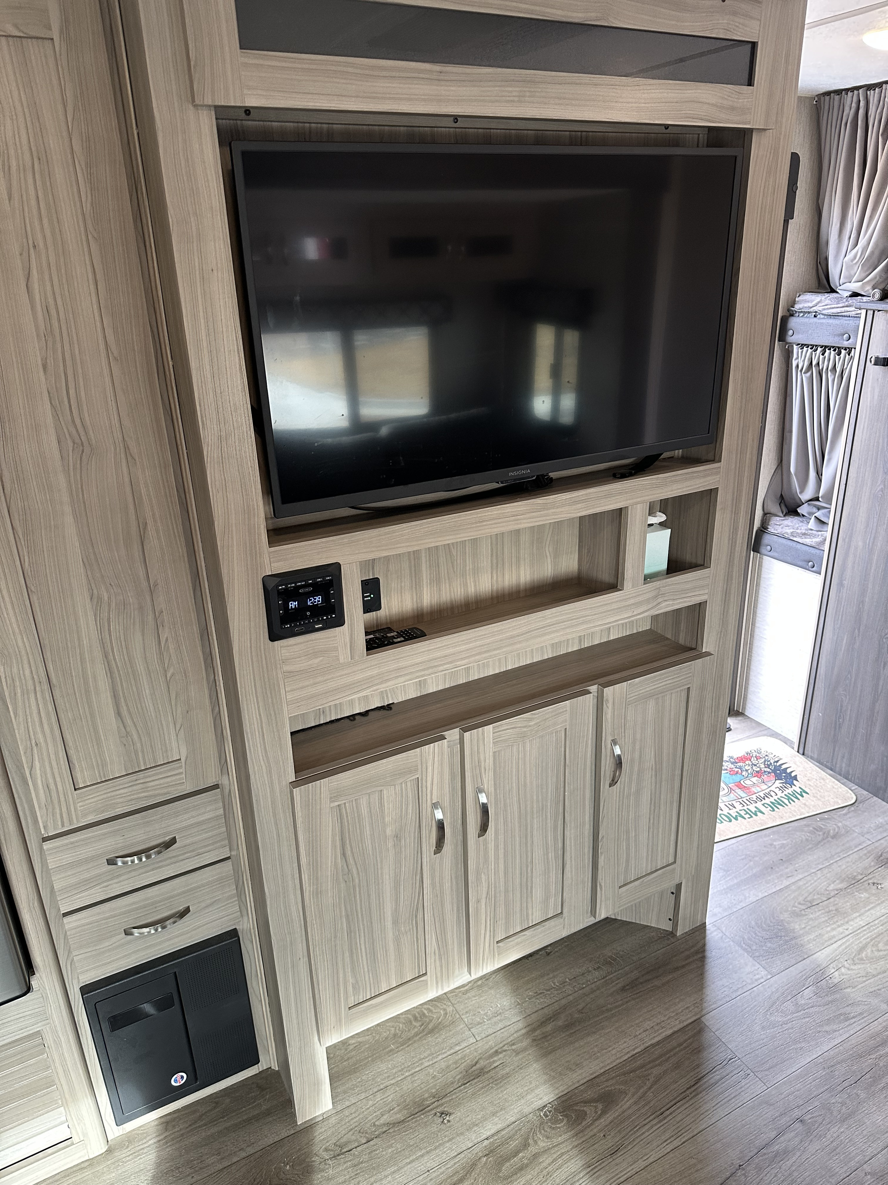 Well-equipped RV rental interior: TV, audio control panel, storage cabinets, and bunk beds, all in light wood finish.. Forest River Coachmen Freedom Express Ultra Lite 2021