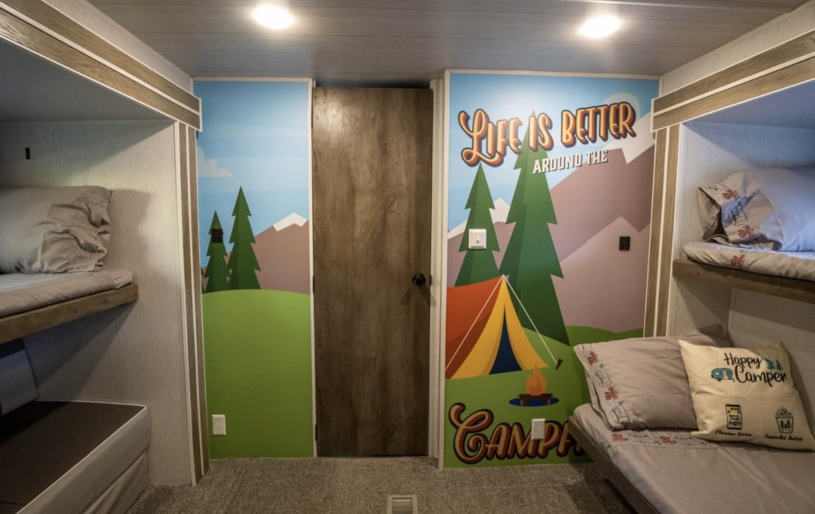 Cozy RV rental interior with bunk beds and a colorful camping mural, perfect for family adventures.. Forest River Salem 2022