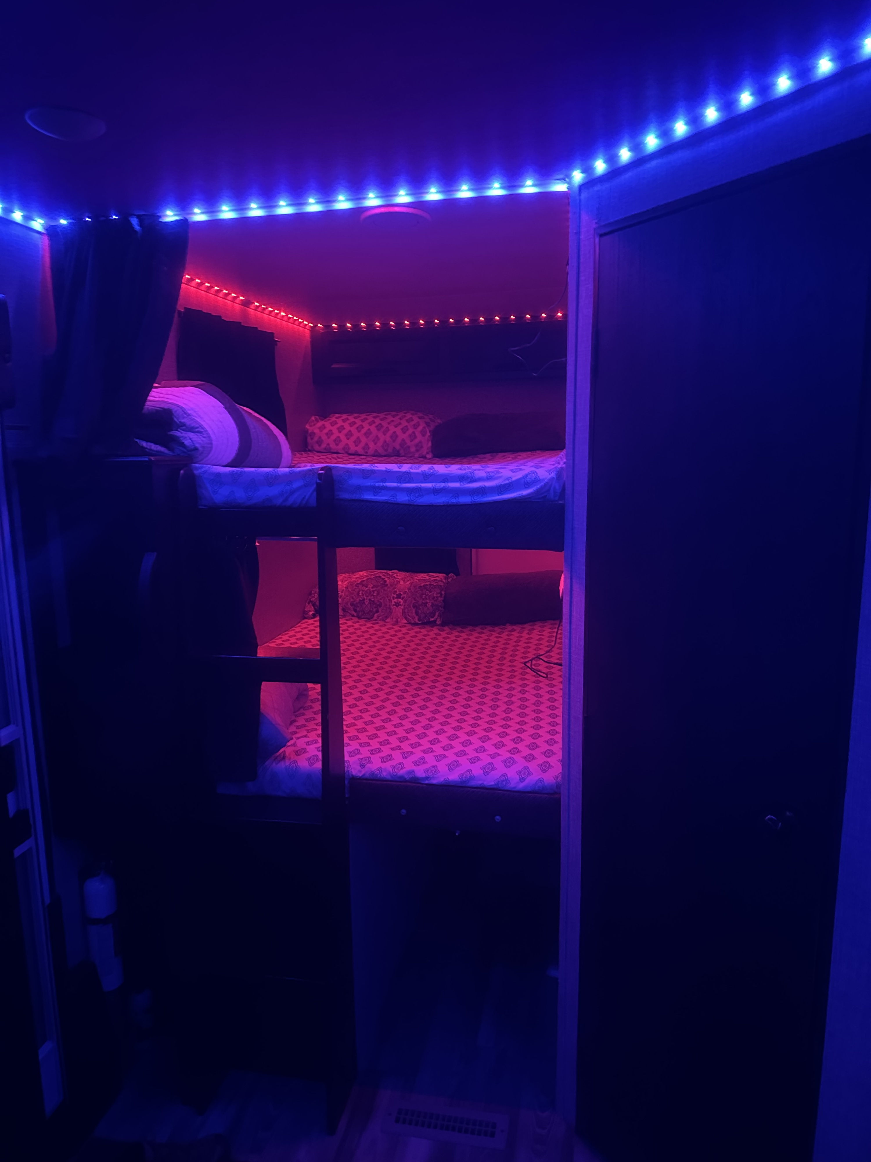 RV rental bunk beds, lit with vibrant blue and red LEDs, for a cozy sleeping space.. Jayco Eagle HT 2022