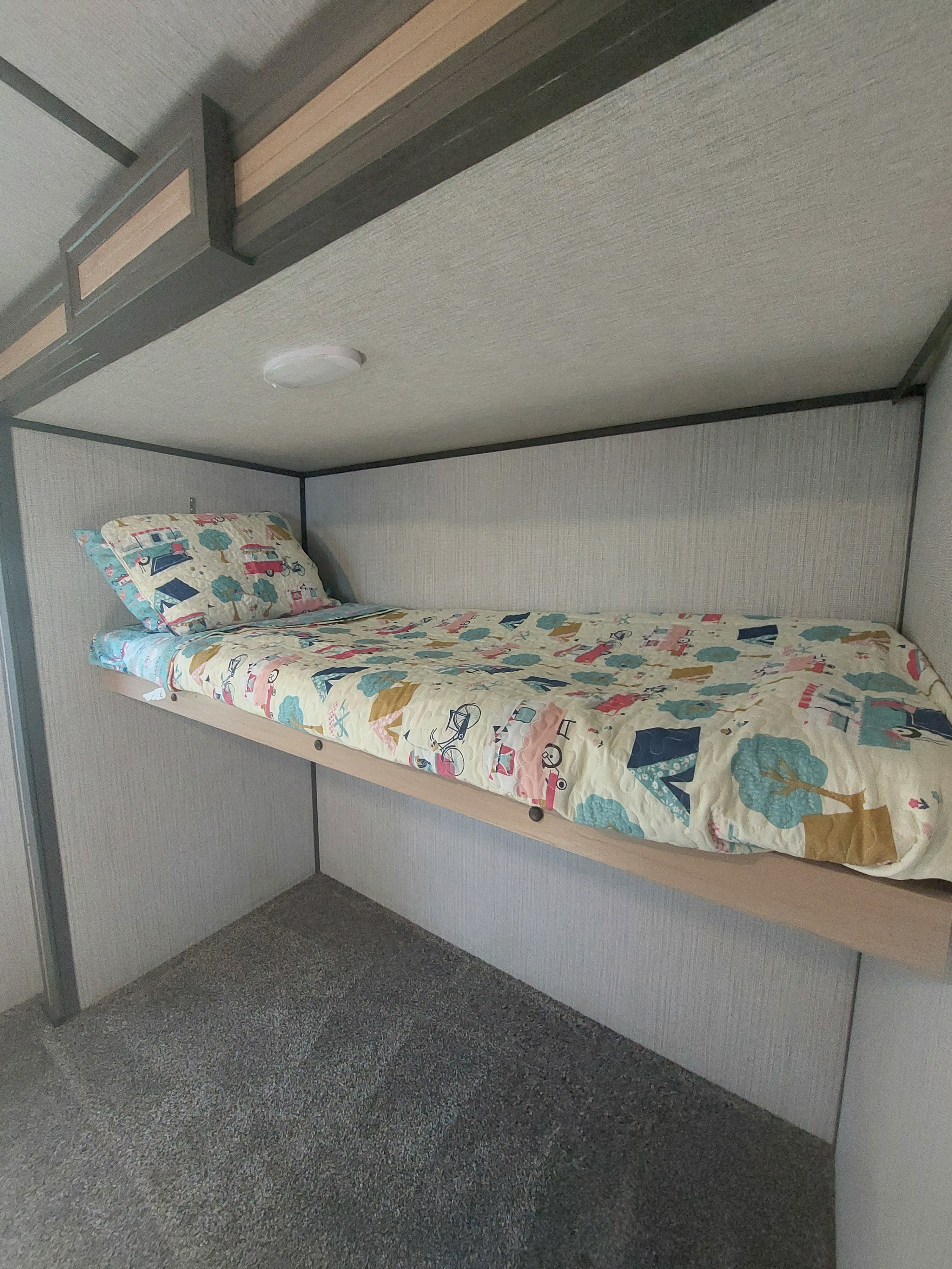 Step inside this cozy RV rental's bunk bed area, featuring a colorful, playful quilt for a comfortable night's sleep.. Cruiser RV Radiance Ultra Lite 2020