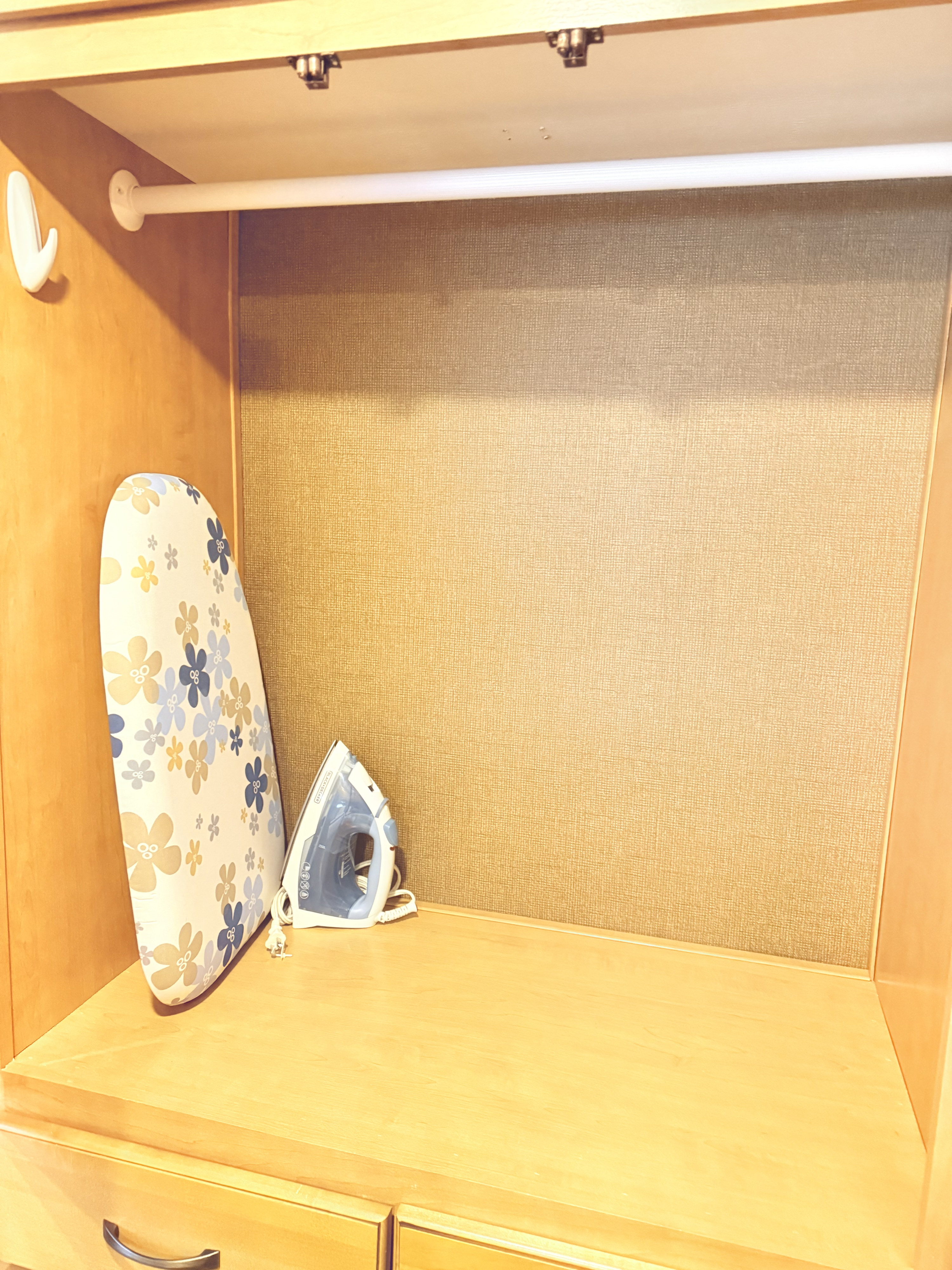 RV rental travel essentials: a compact ironing board and steam iron stored in a light wood cabinet with a hanging rod.. Thor Chateau 2017