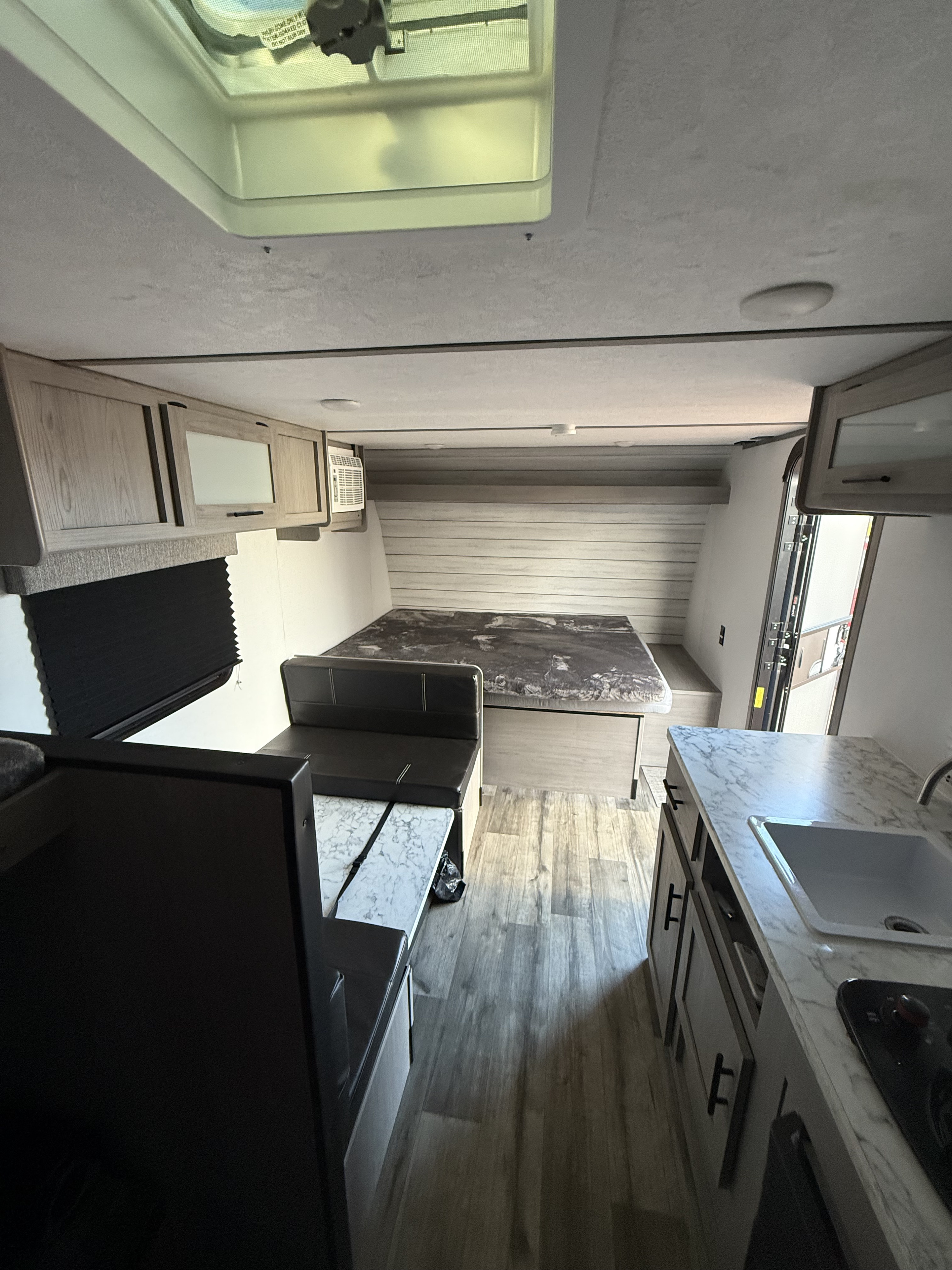 Spacious RV rental interior featuring a cozy bed, dinette, and full kitchen, ready for your next adventure.. Dutchman Colorado 2025