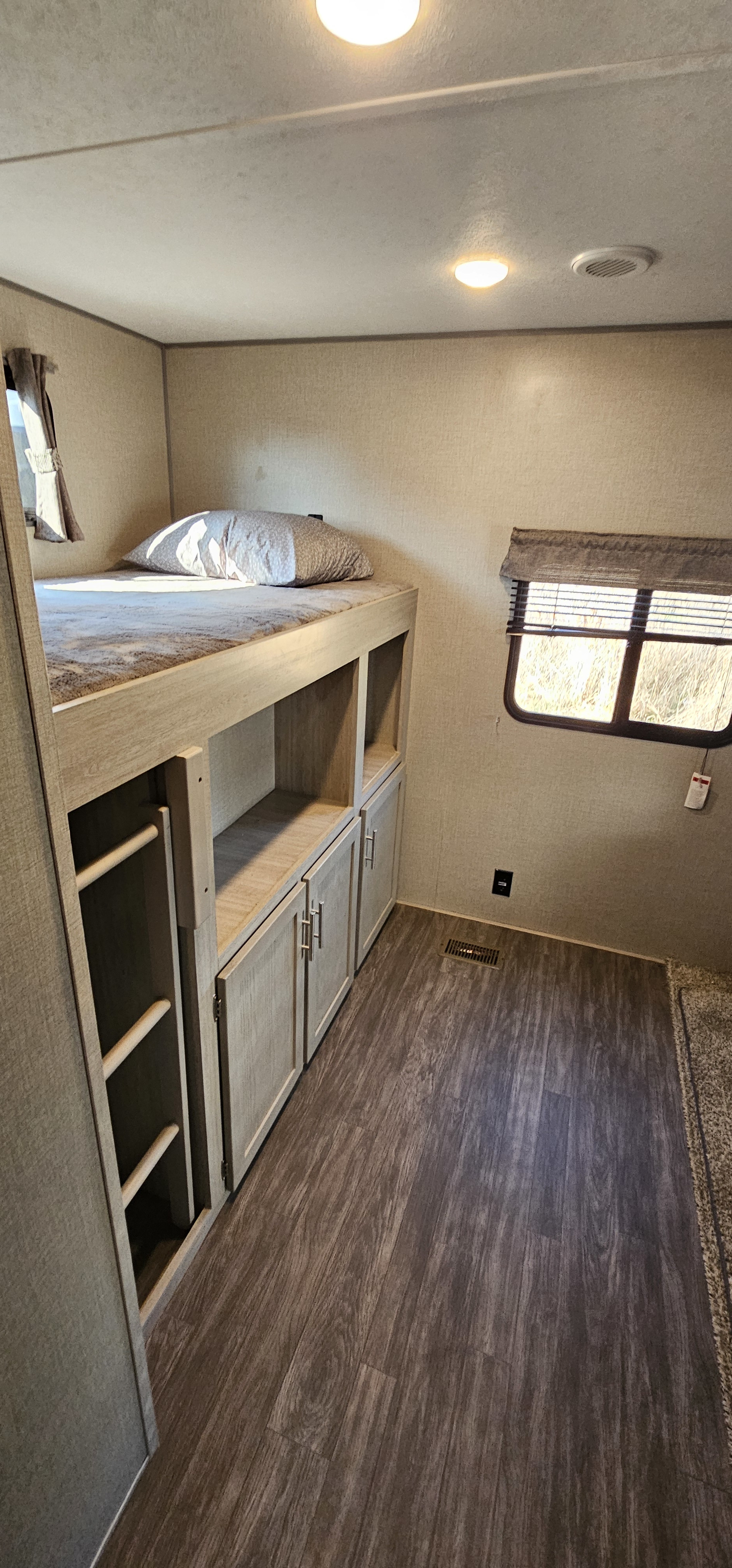 This RV rental features cozy bunk beds, storage, and modern wood-look floors, perfect for travel comfort.. Forest River Aurora 2022