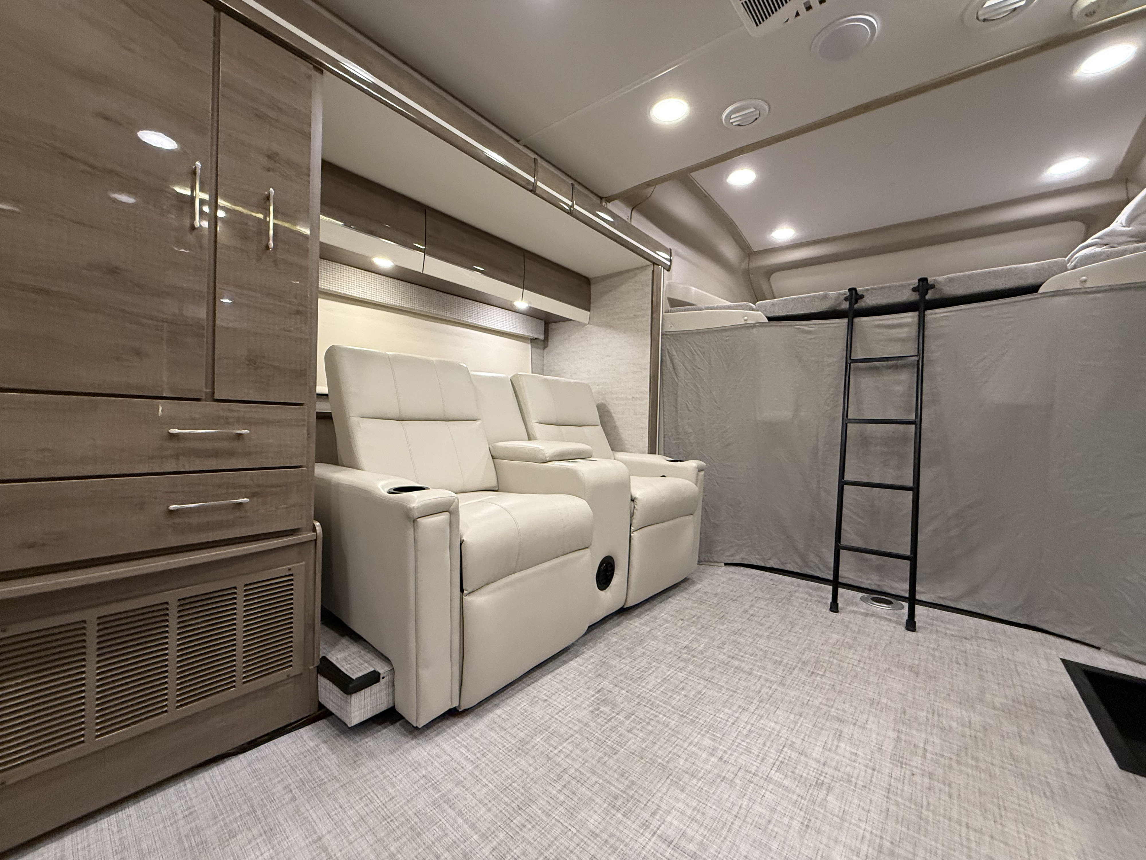 Spacious RV rental interior featuring plush theater seating, a bunk bed with ladder, and built-in storage for comfort.. Entegra Coach Qwest 24L 2022