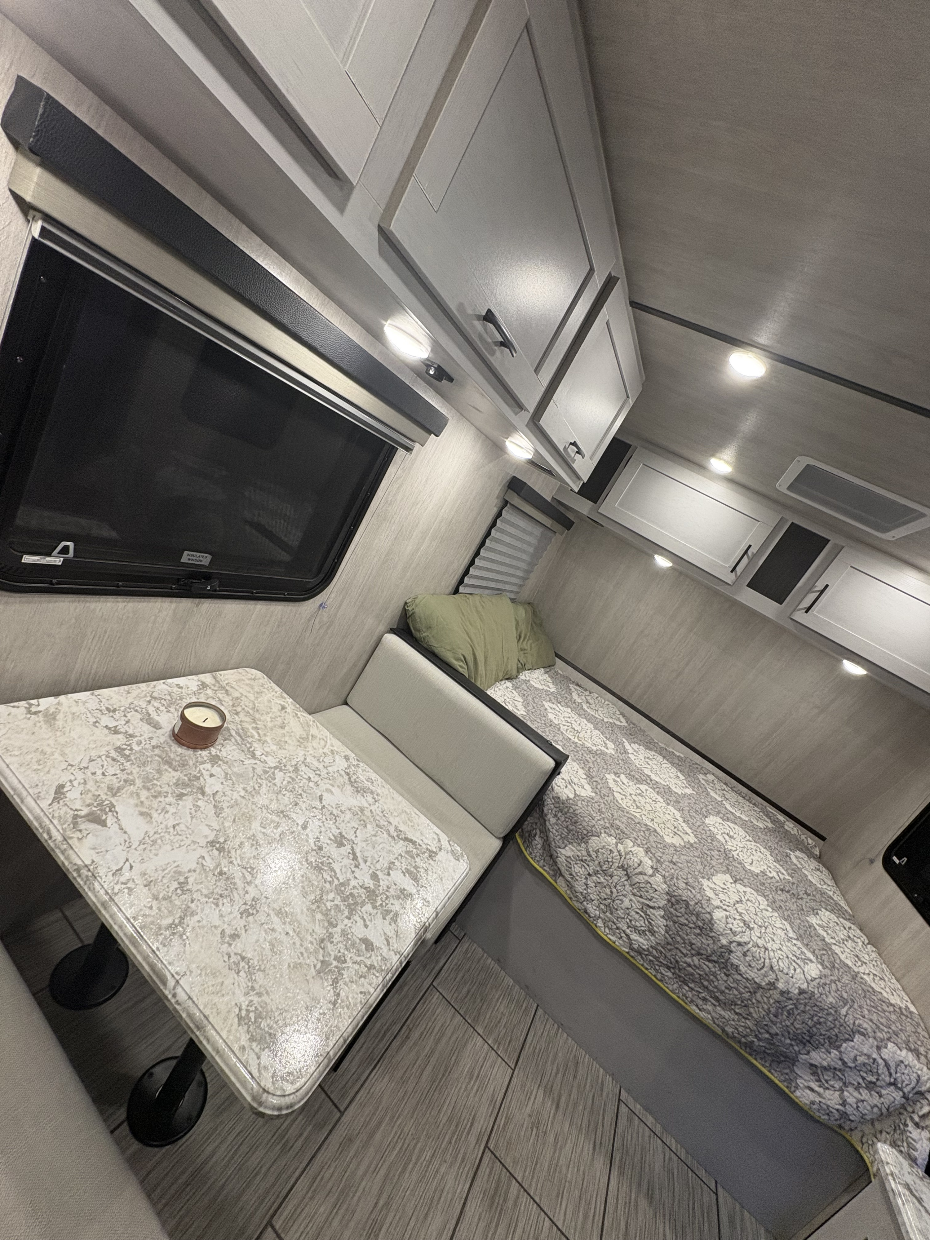 Cozy modern RV interior ready for your next rv rental adventure, featuring a dinette and bed area.. Genesis supreme Surf side limited 16bb 2023