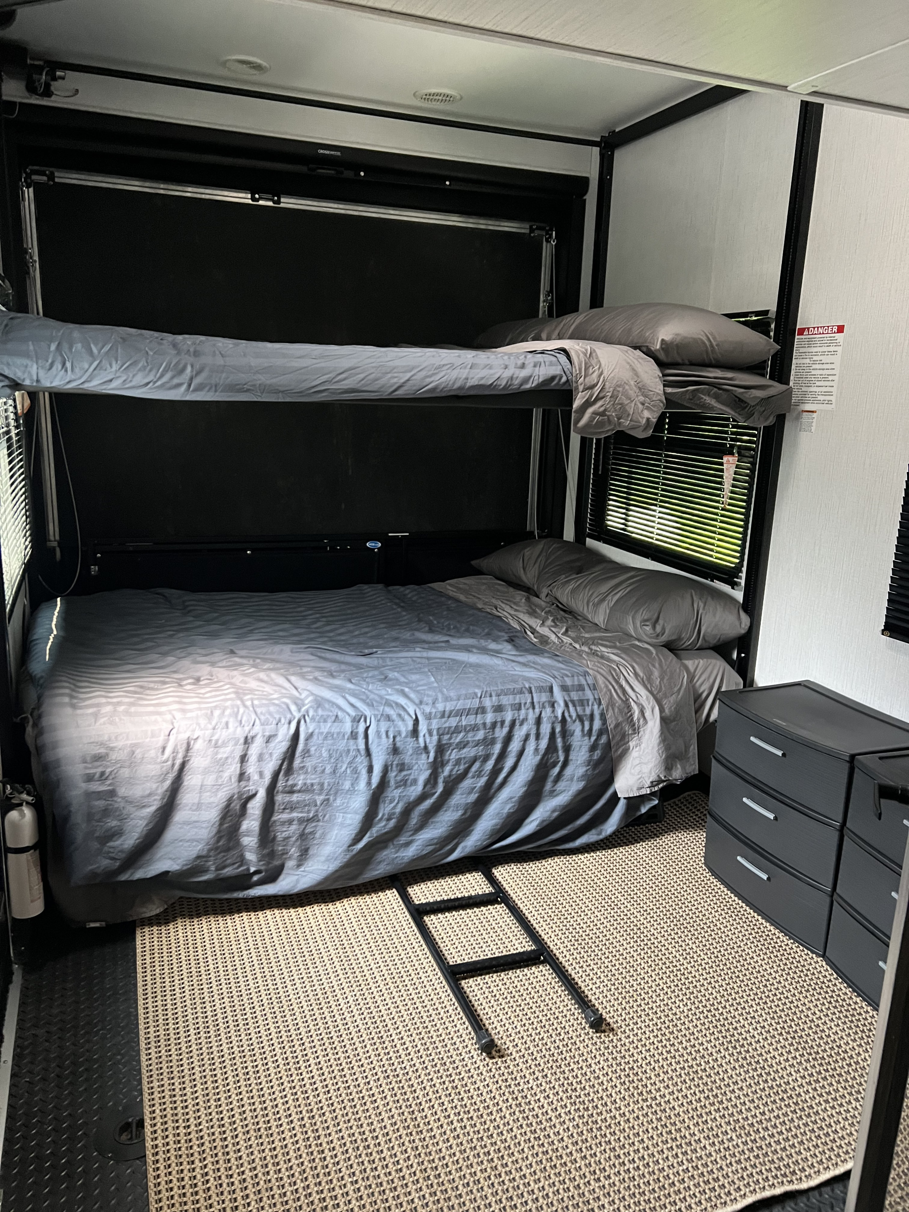Functional RV rental interior with stacked bunk beds and cozy bedding. Perfect compact sleeping space for your next adventure.. Heartland RVs Fuel Toy Hauler 2022