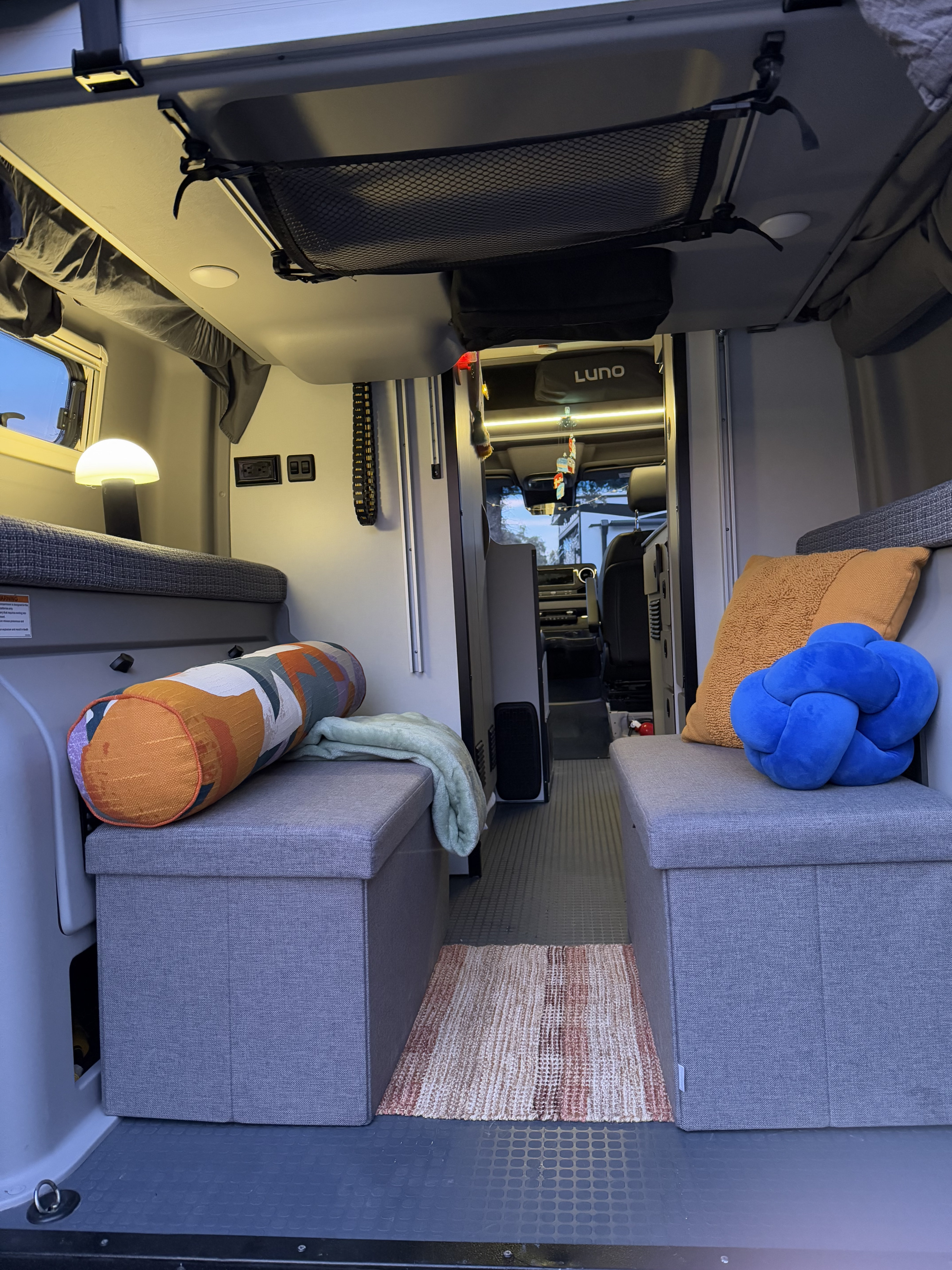 Cozy RV rental interior with convertible benches, ambient lighting, and clever storage solutions for travelers.. Winnebago Revel 2023