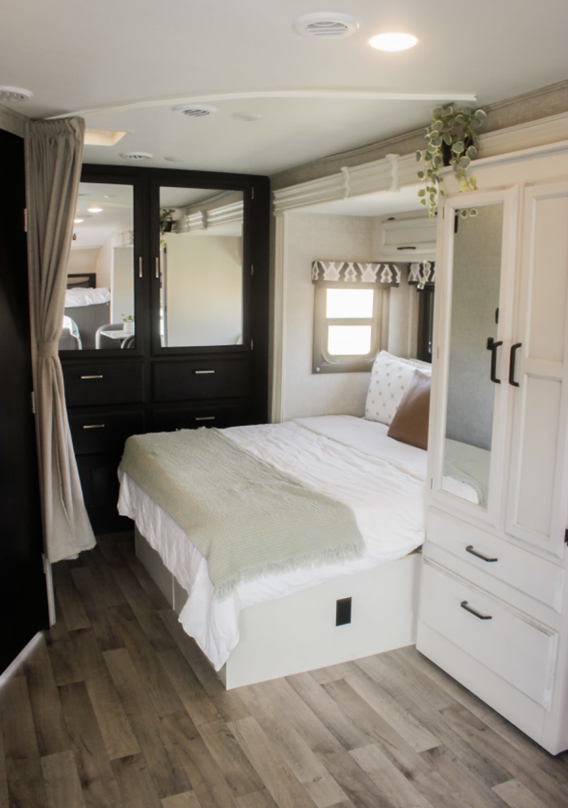 Cozy and modern RV rental bedroom featuring a comfortable bed, mirrored wardrobes, and wood-look flooring with ample storage.. Jayco Redhawk 2022