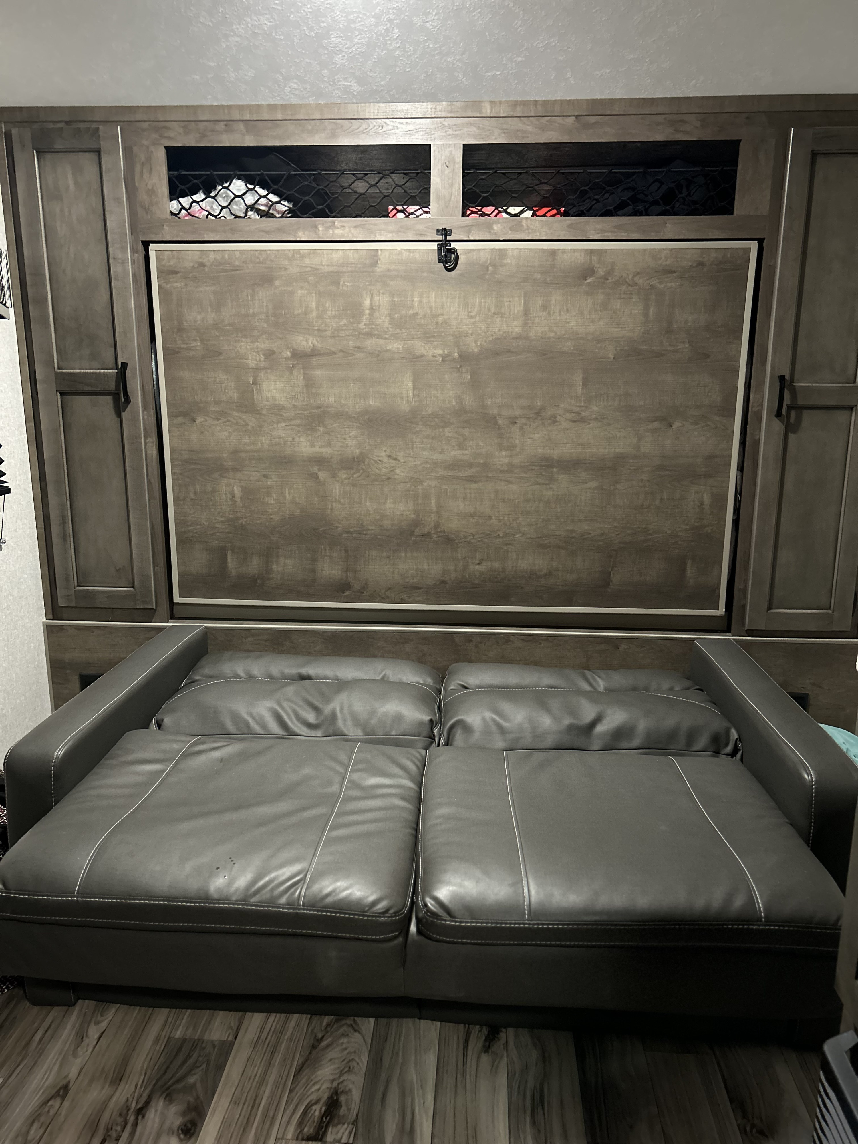 RV rental: Plush gray leather sofa, convertible to bed, with integrated wooden storage unit and overhead netted compartments.. Venture SONIC LITE 2022