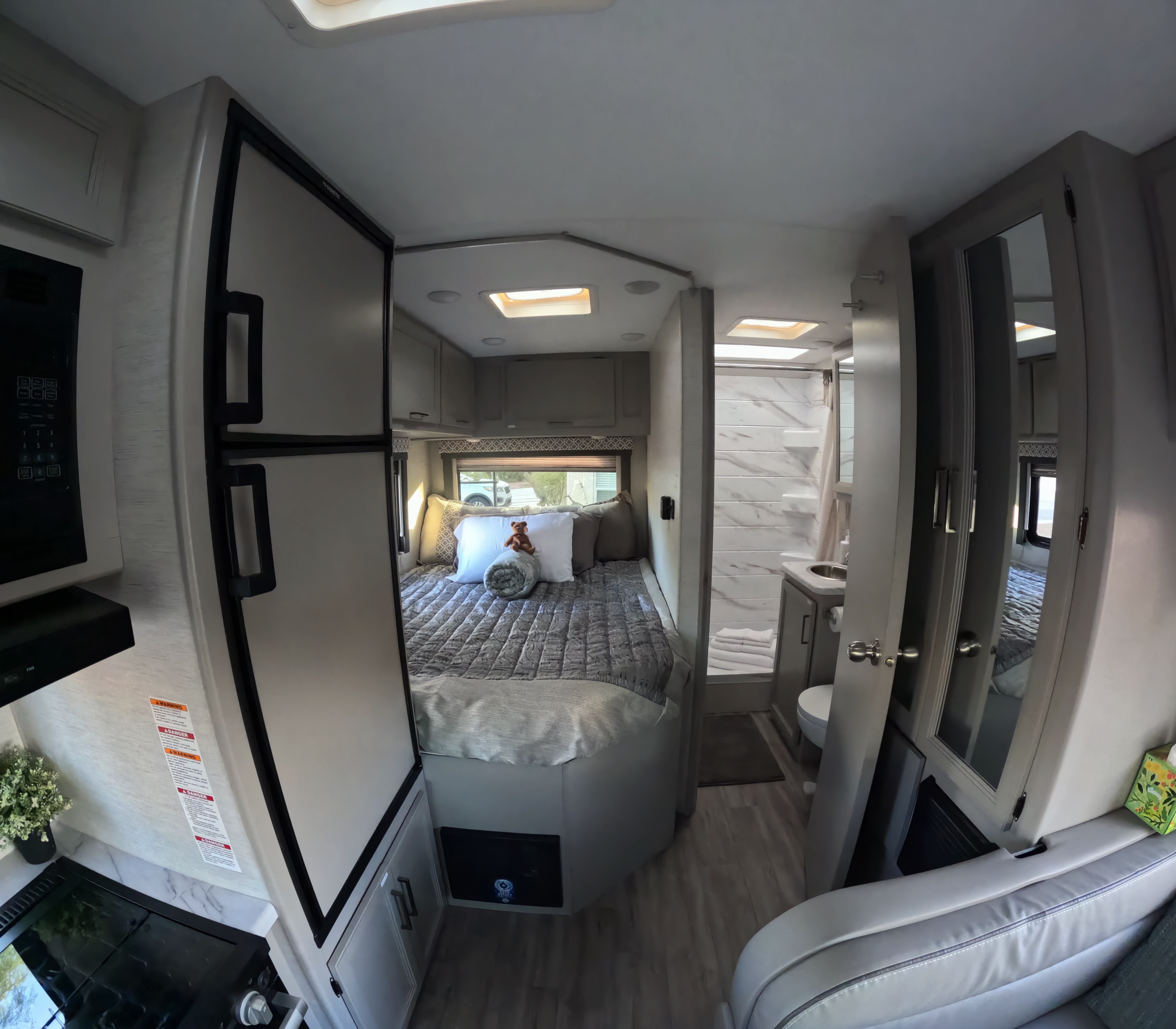 Inside this rv rental: a full kitchen, comfortable bed, and compact bathroom for convenient living on the road.. Thor Freedom Elite 2024
