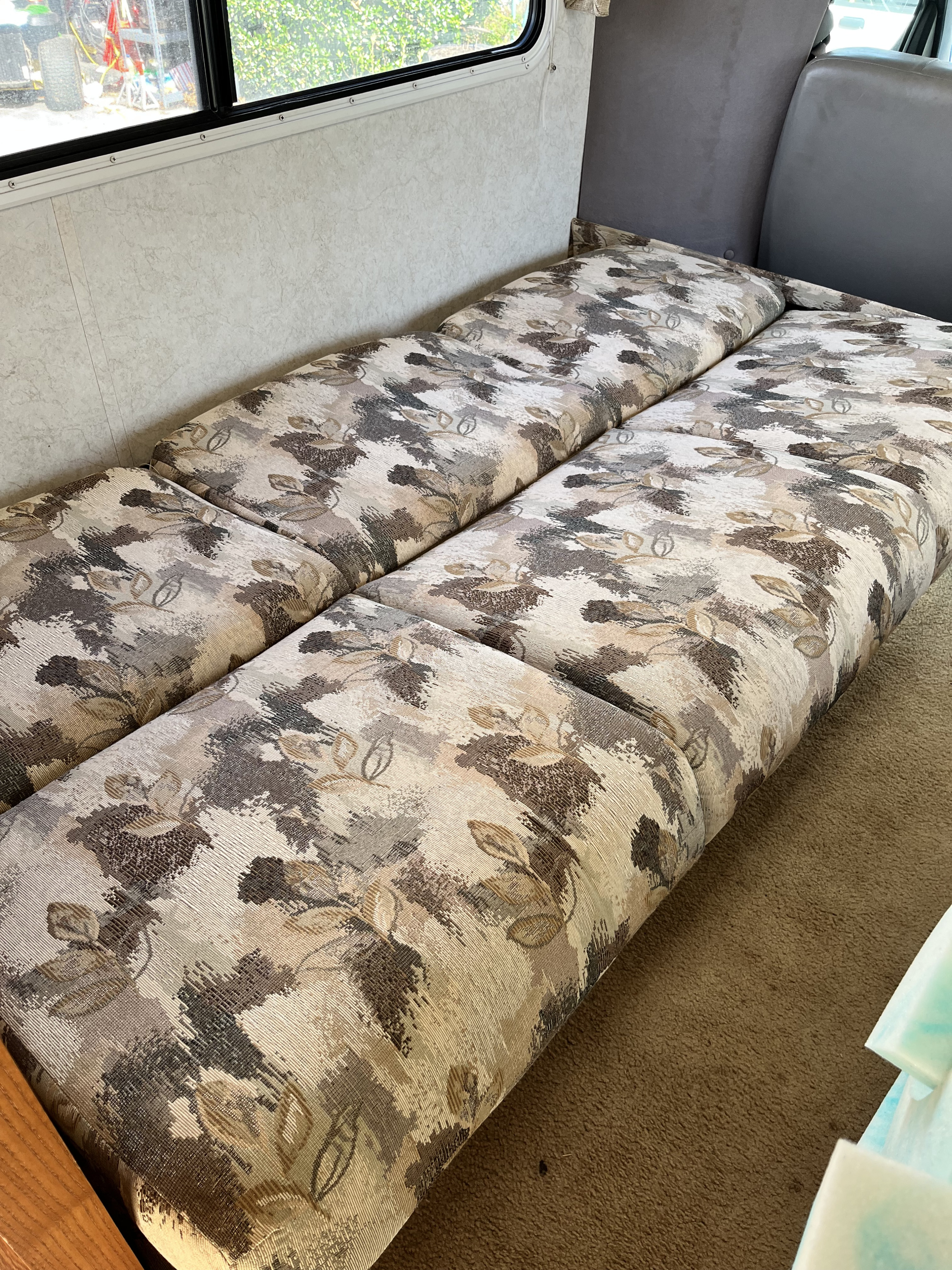 RV rental interior: brown & beige patterned bench cushions configured for sleeping by the window.. Gulfstream 5210 2003