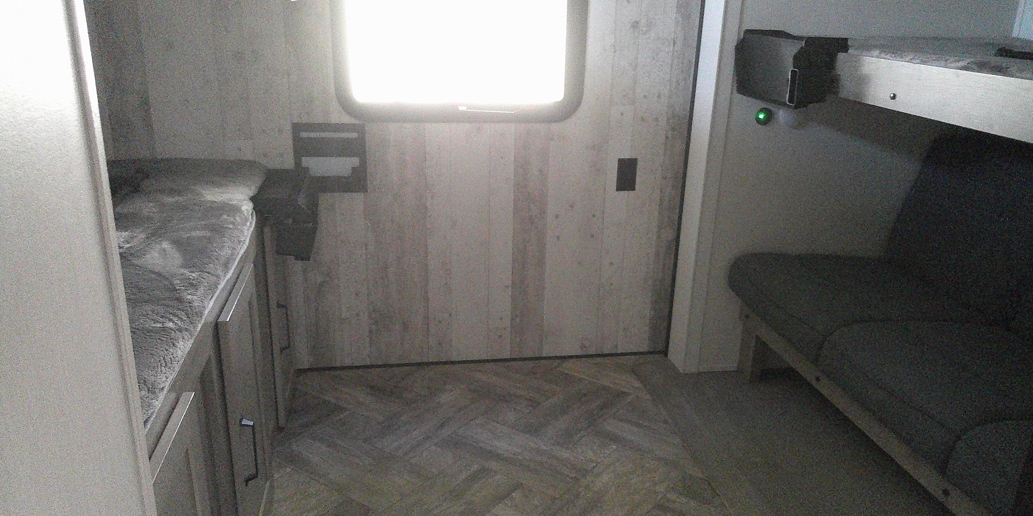 Compact RV rental interior featuring a lower bunk, an upper bunk over a sofa, and storage cabinets, ideal for travel.. Puma palomino 2023