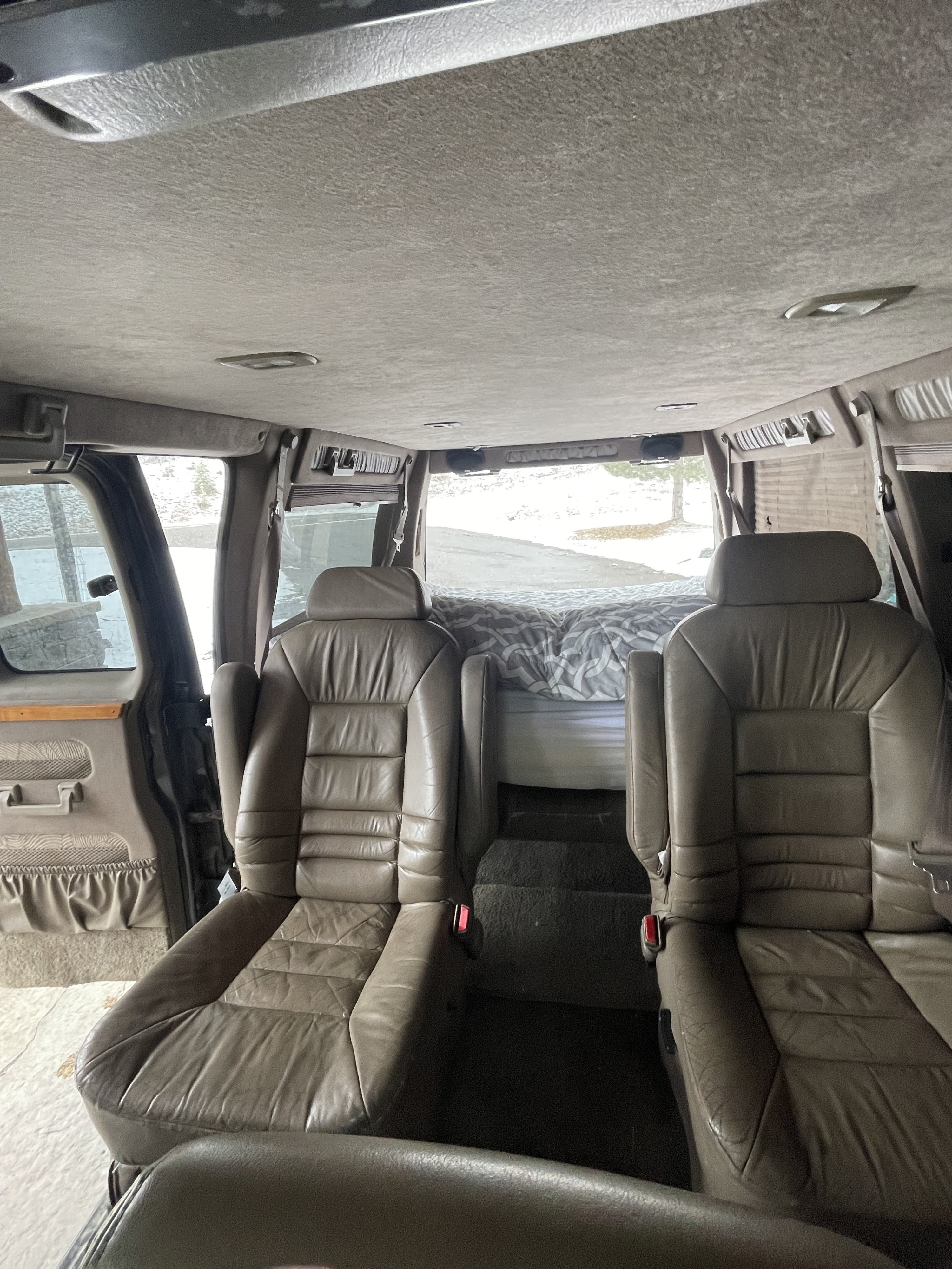 Step inside this RV rental: plush leather seating & a rear bed in a customized conversion van interior.. Chevrolet Express Van 1999