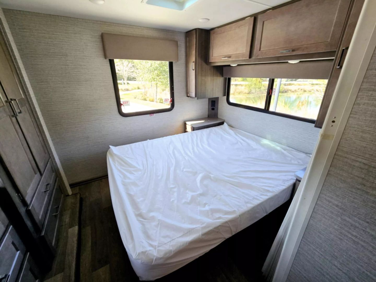 Cozy RV rental bedroom featuring a comfortable bed, ample storage, and scenic window views for your next adventure.. Winnebago Minnie Winnie 2024